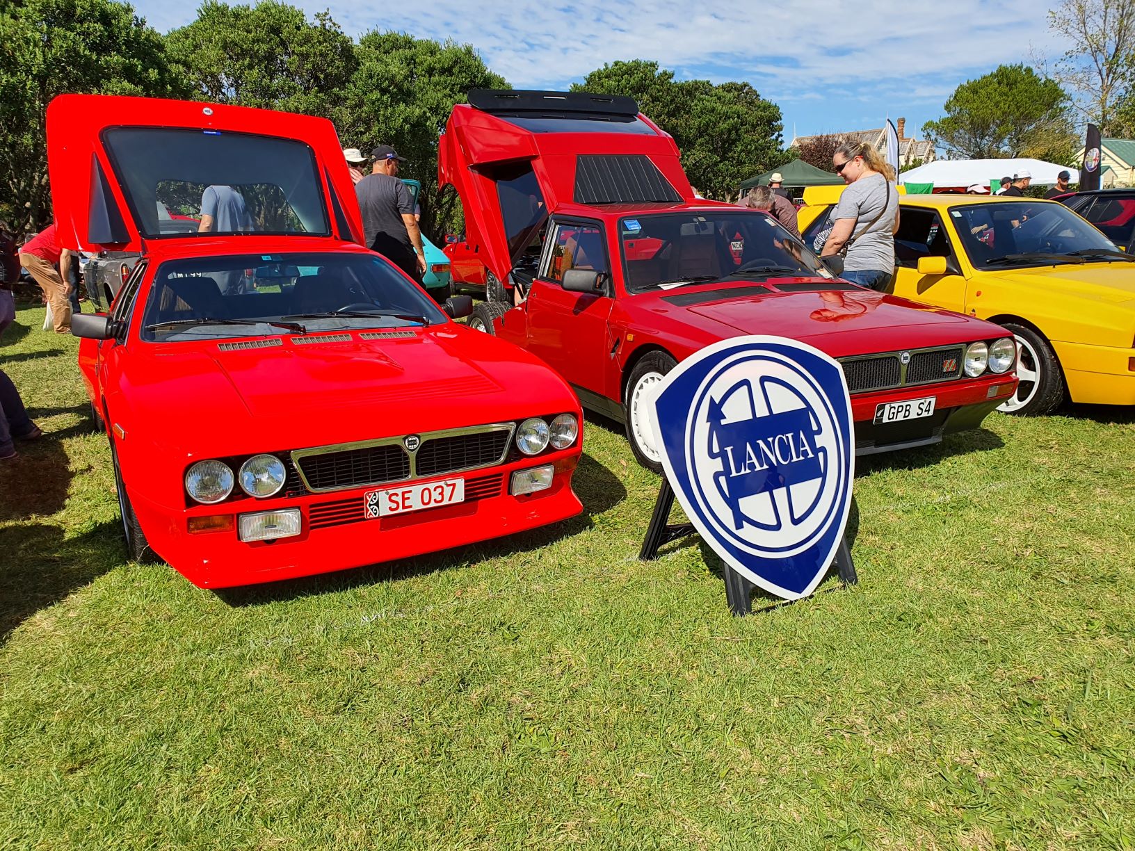 Two red Lancias, one is an 037 rally homage