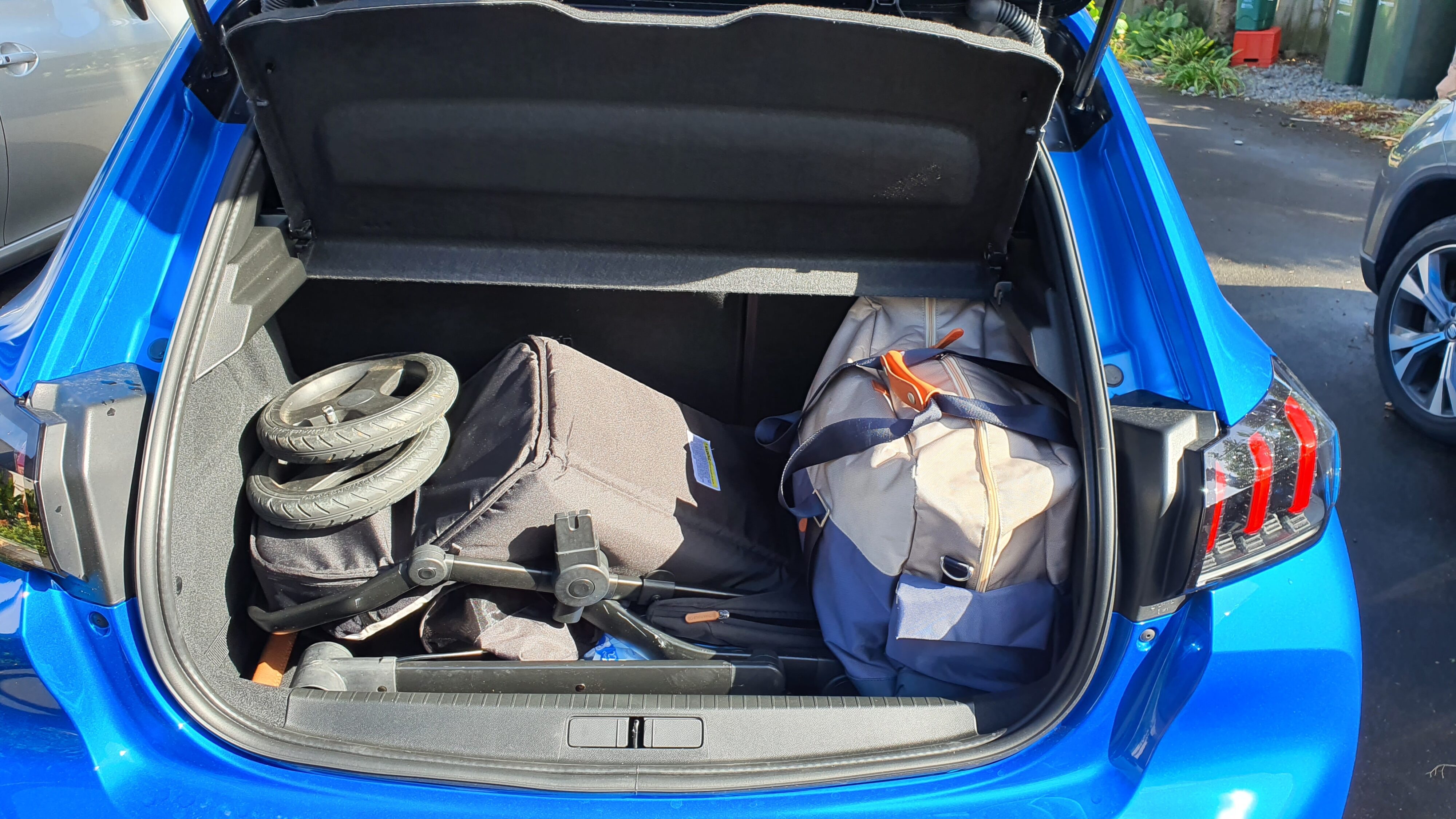 Pram and bags packed into the boot of a 2022 Peugeot 208 GT.