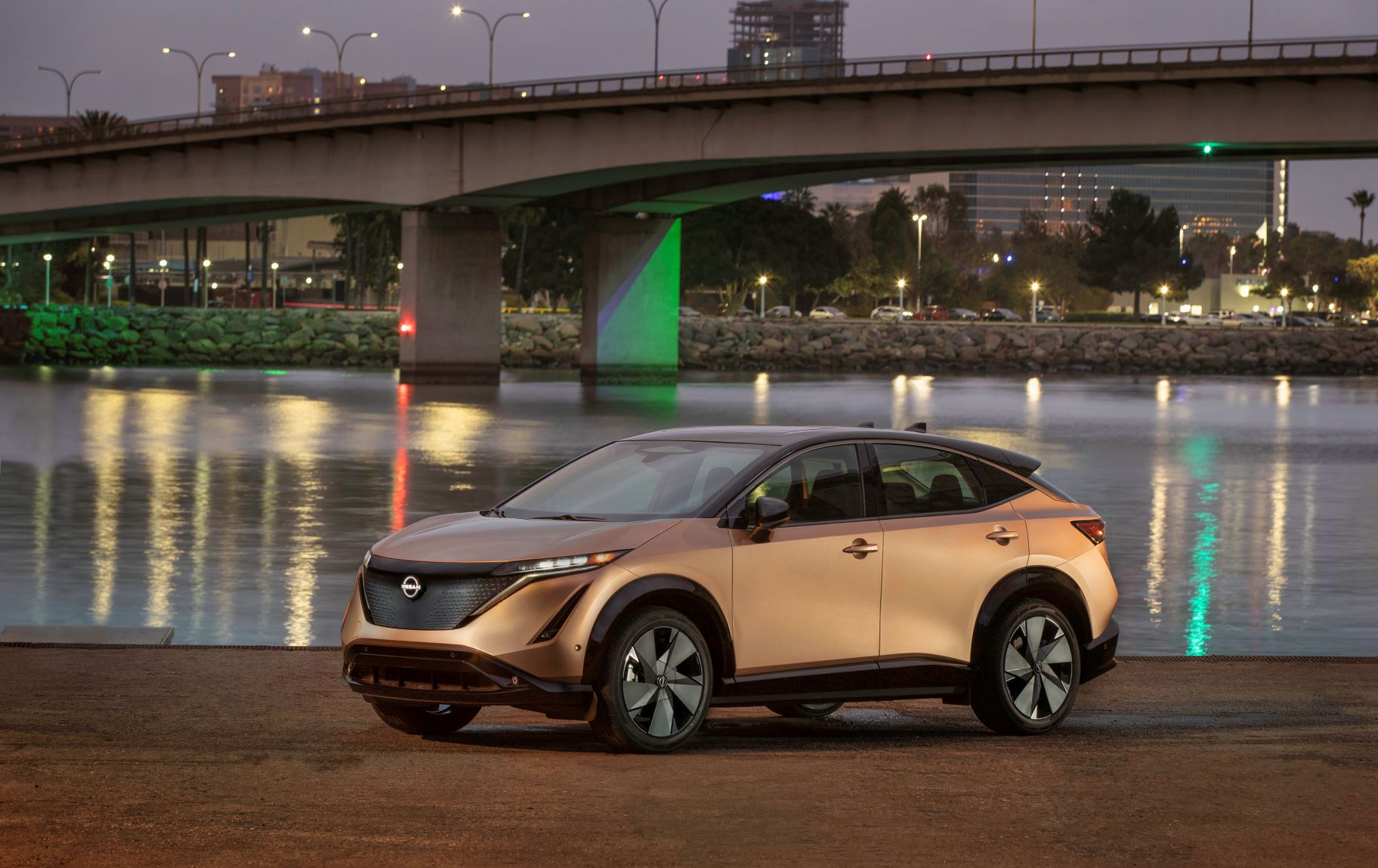 Zoomed out view of the Nissan Ariya EV with a city in the background