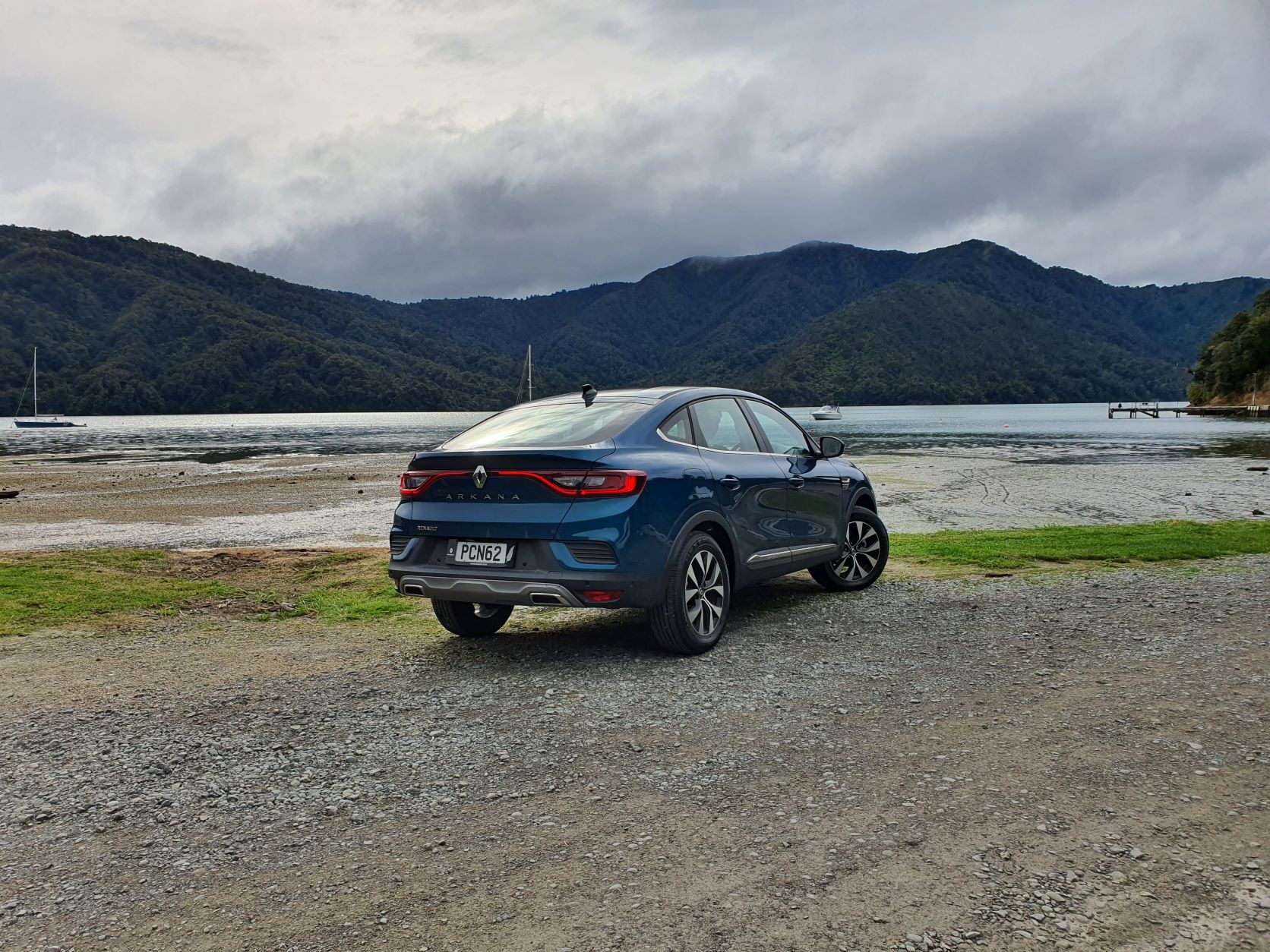 Rear three quarters view of the Renault Arkana with Picton, New Zealand in the background