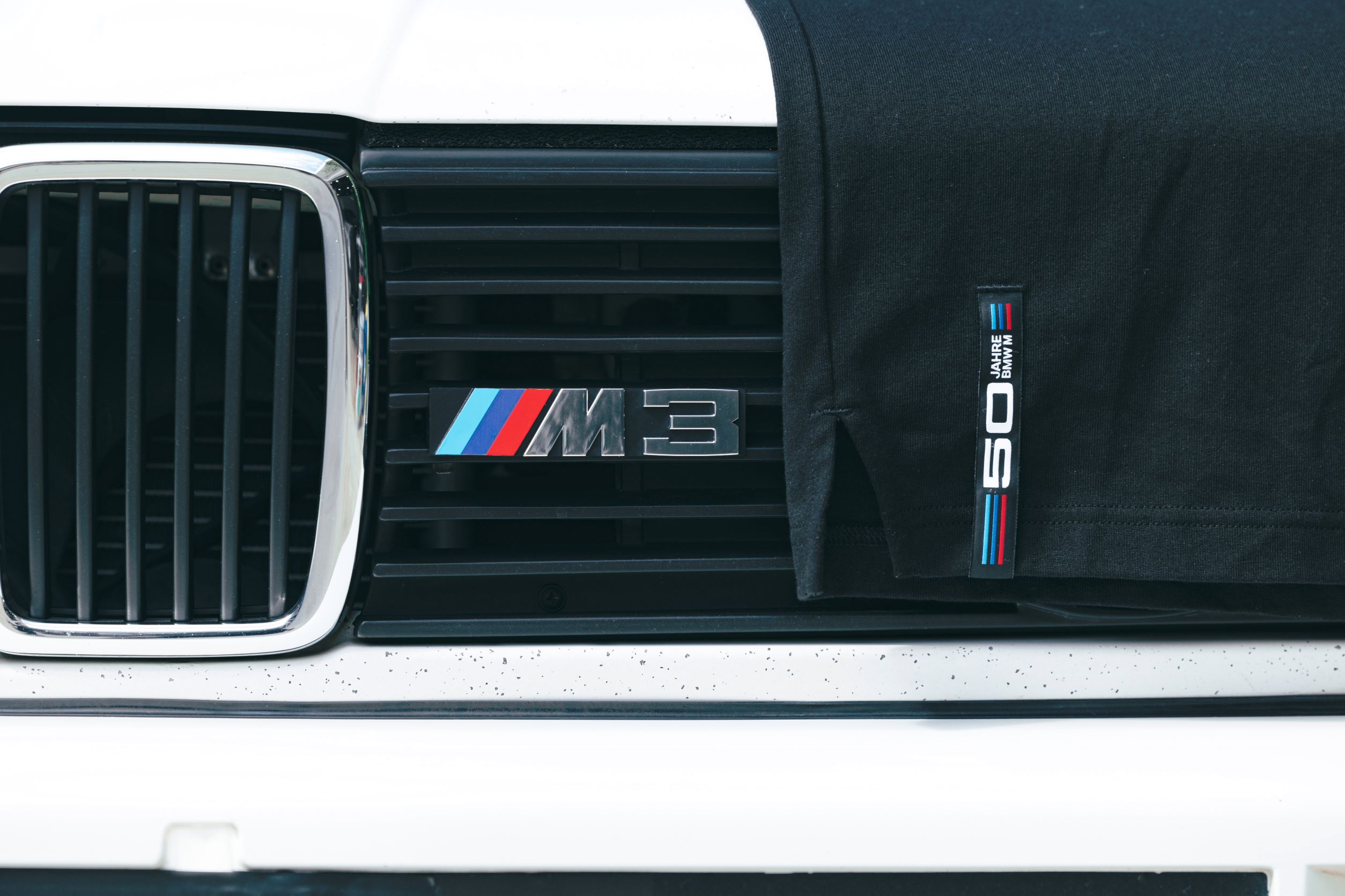 BMW 50 years of M t shirt draped over a BMW M3