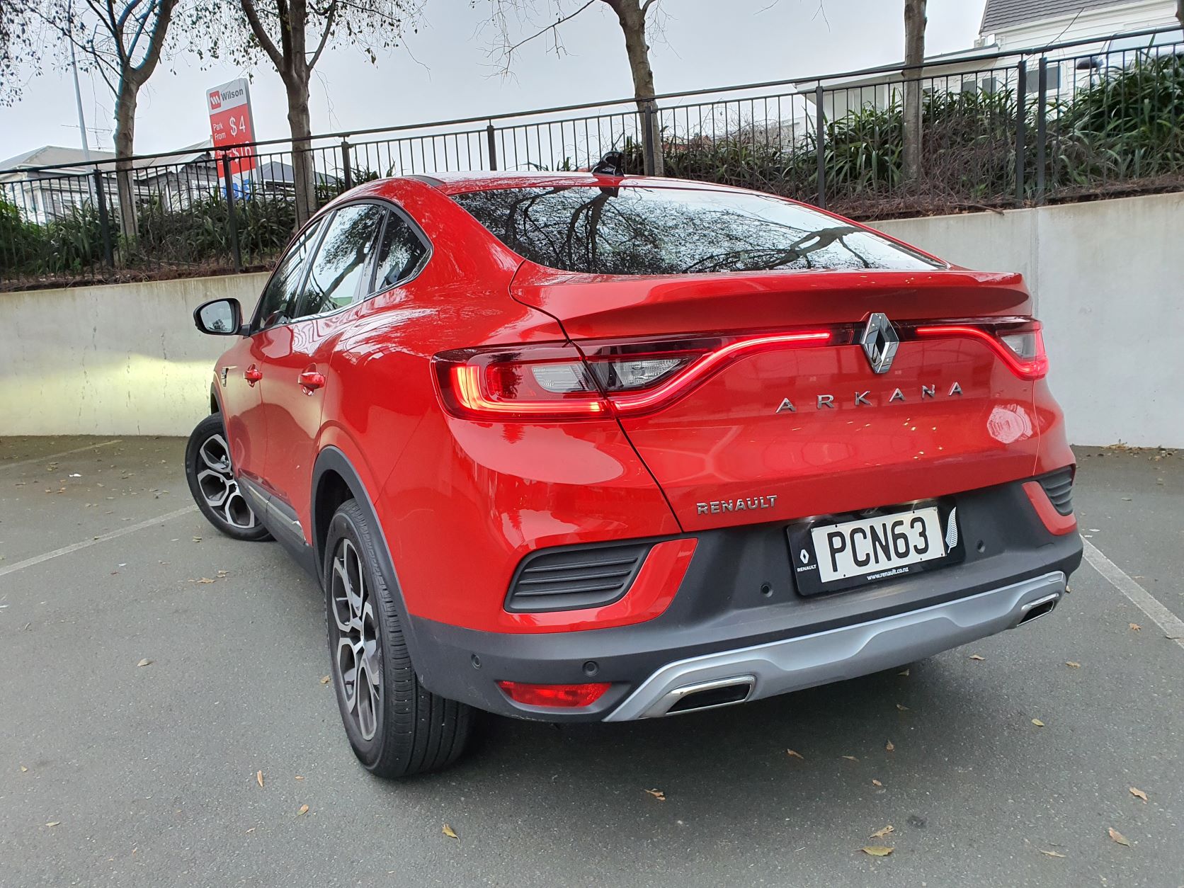 Rear close up three quarters view of the Renault Arkana in red