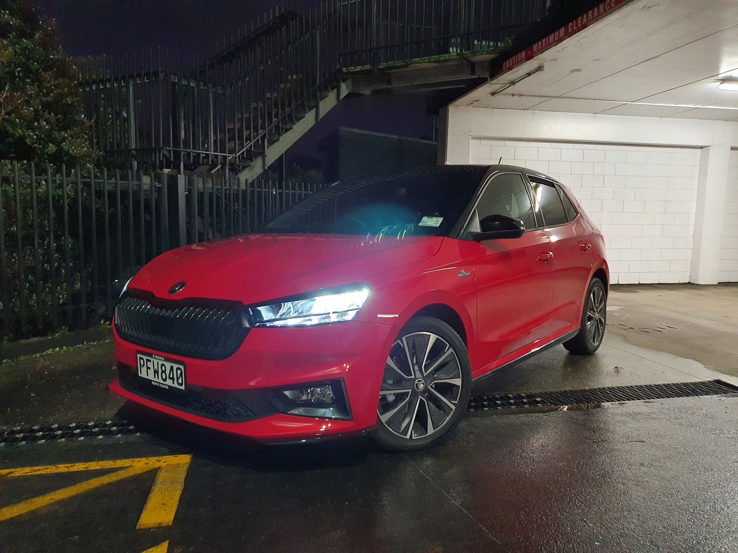 Front three quarters view of a 2022 Skoda Fabia Montecarlo in red at night