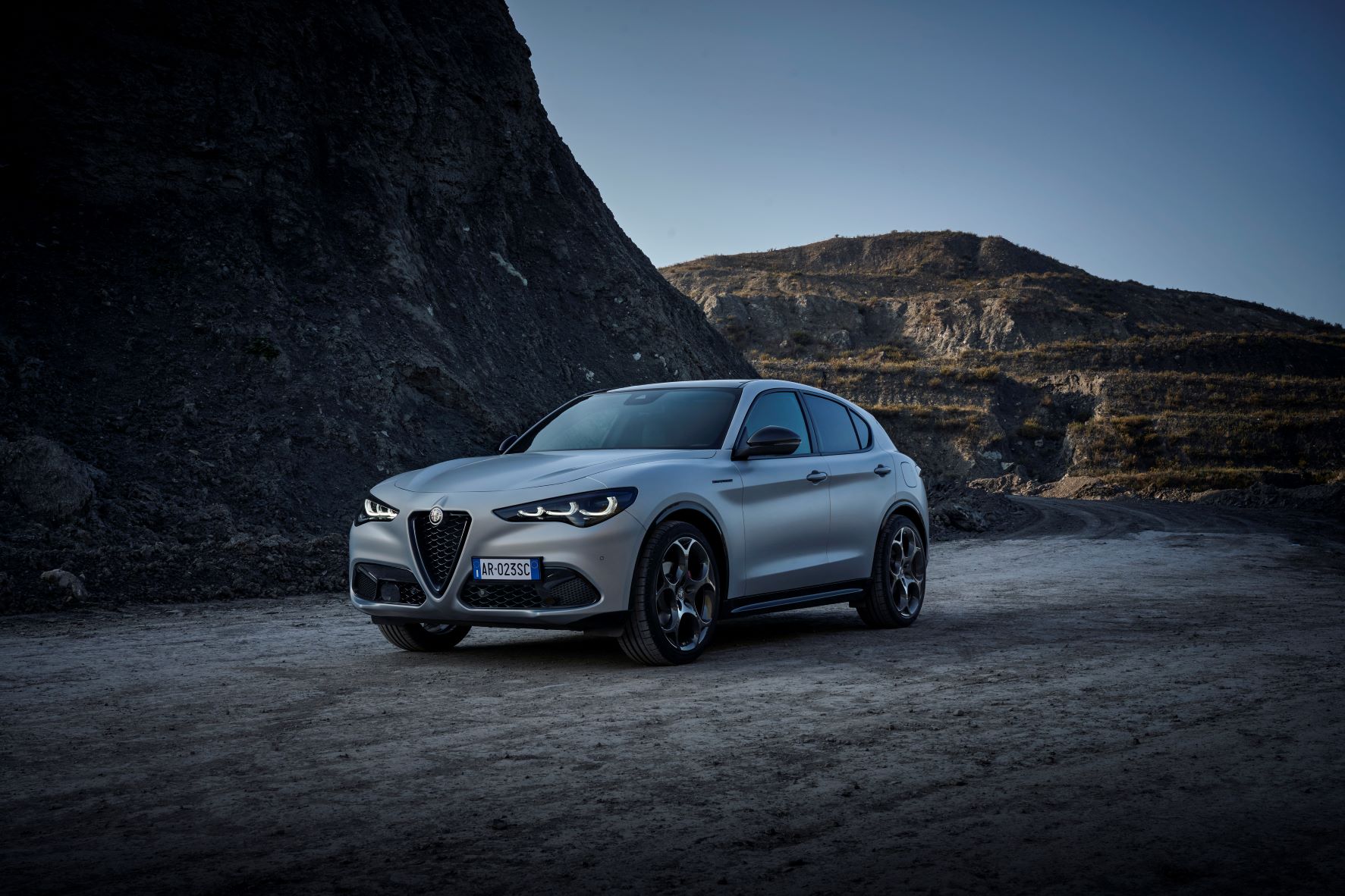 A moving front three quarters photo of the 2023 Alfa Romeo Stelvio in gray