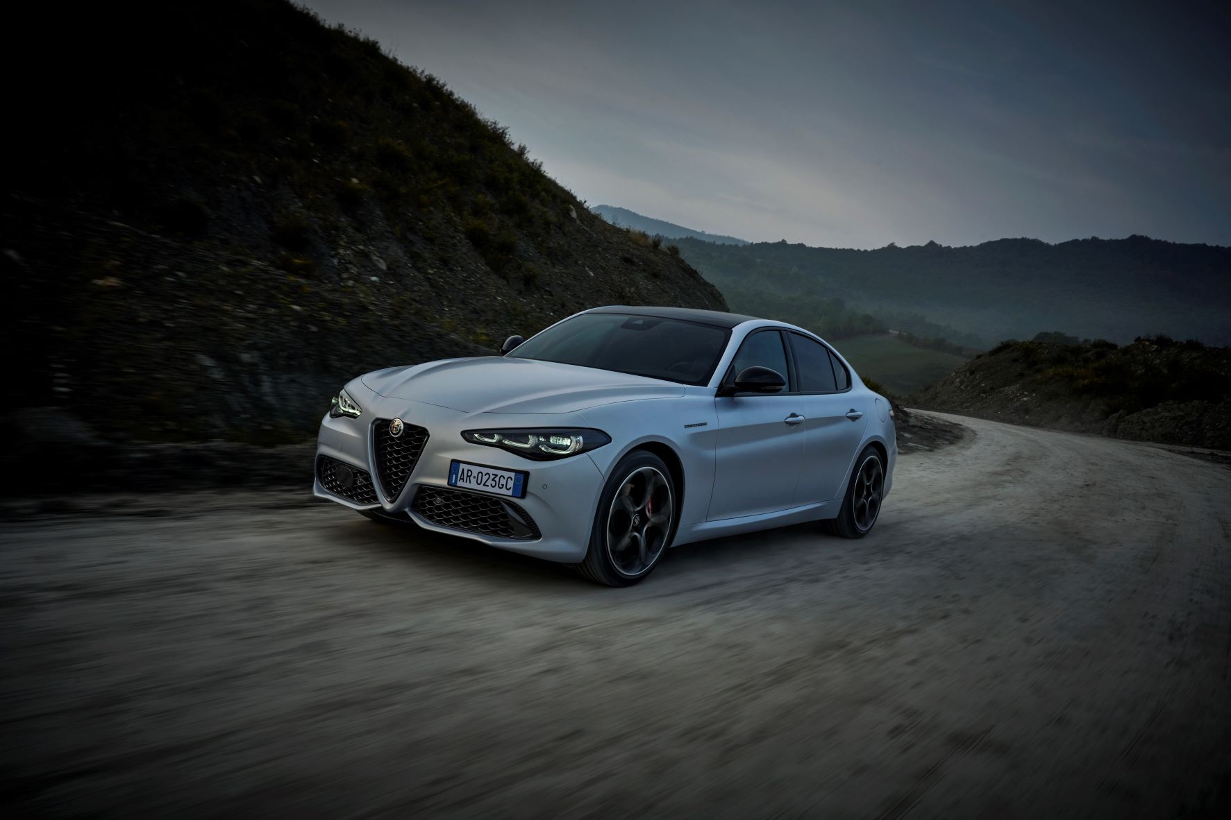 A moving frontal three quarters view of the 2023 Alfa Romeo Giulia sedan in white