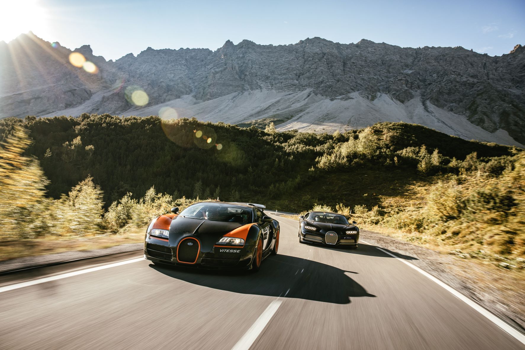 A Bugatti Veyron and Chiron on a mountain road
