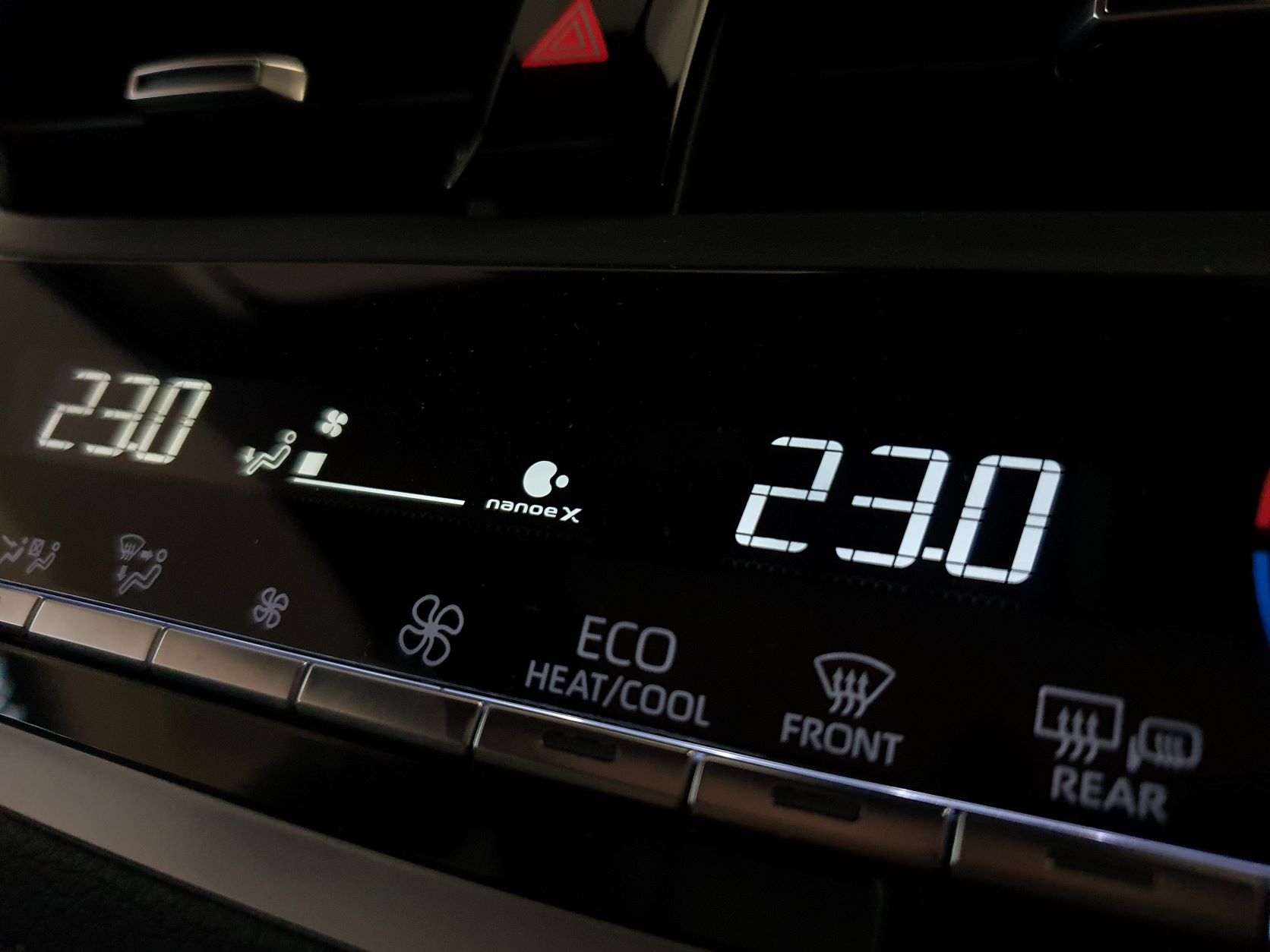 Air conditioning controls and a Panasonic nanoeX logo on the dashboard of a 2022 Toyota Corolla Cross Limited Hybrid E-Four AWD in Safari Green