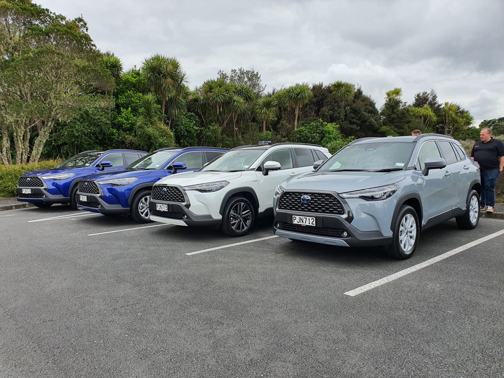 Front three quarters view of the four different Toyota Corolla Cross models. Two in blue, one in white and one in grey.