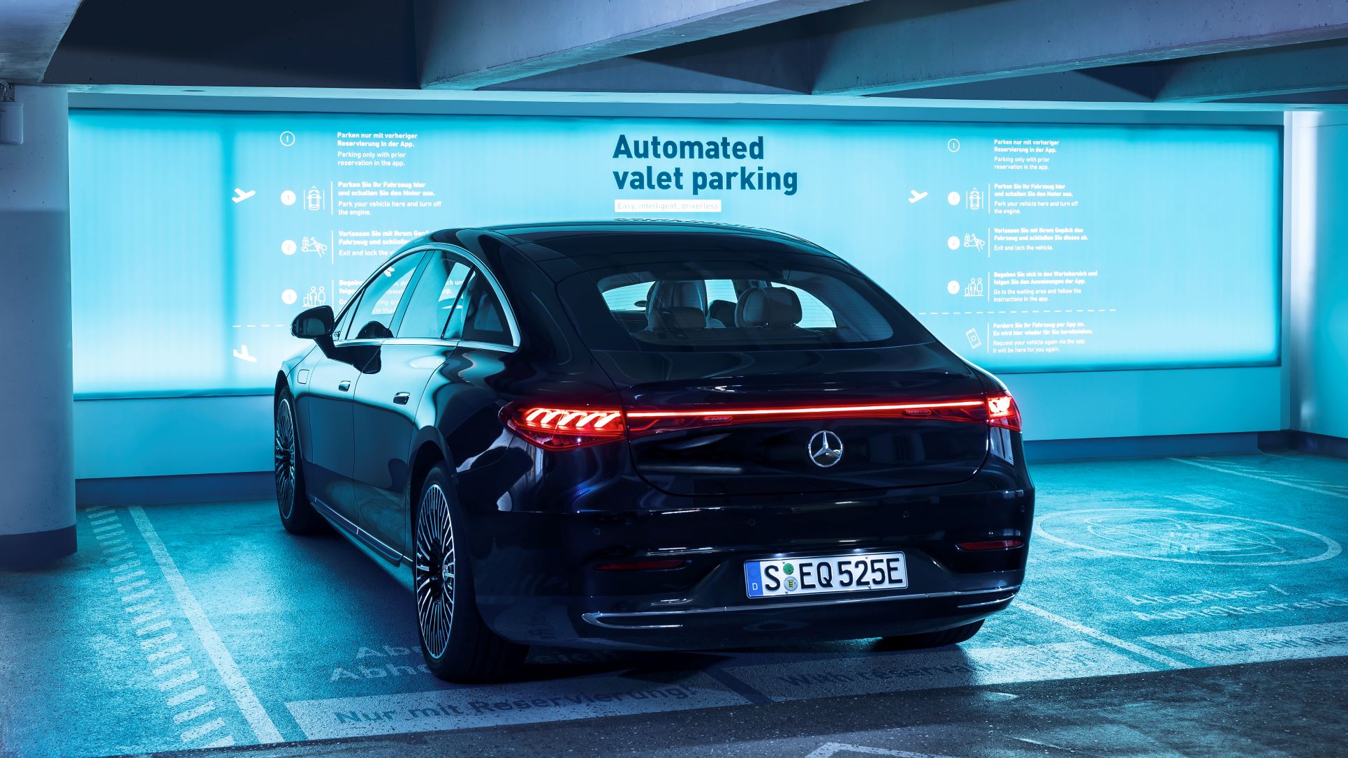 Rear three quarters view of a black Mercedes-Benz EQS sedan parked at a dedicated parking bay at Stuttgart Airport, Germany.