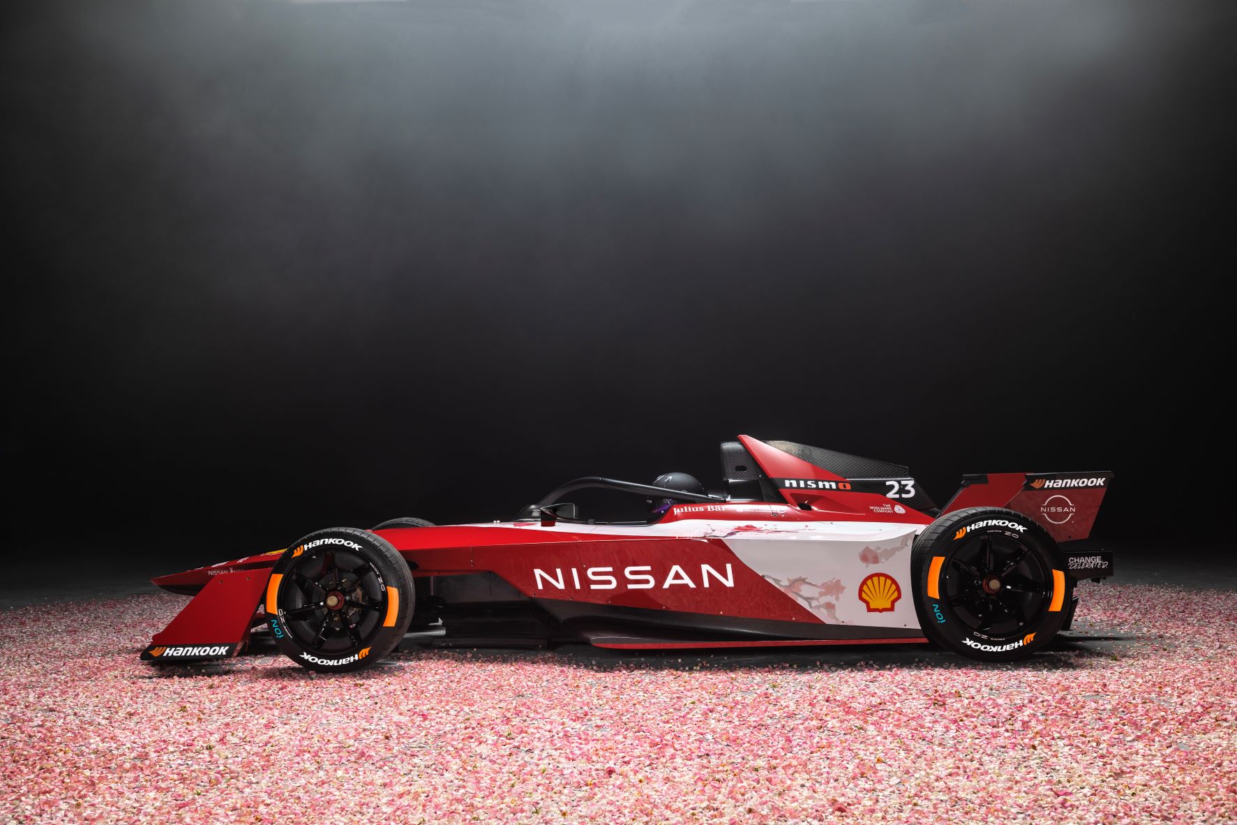 Side view of Team Nissan's Formula E Gen 3 racecar in red and white.
