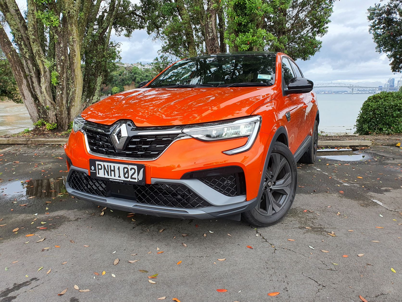 Front three quarters view of an orange Renault Arkana R.S Line SUV