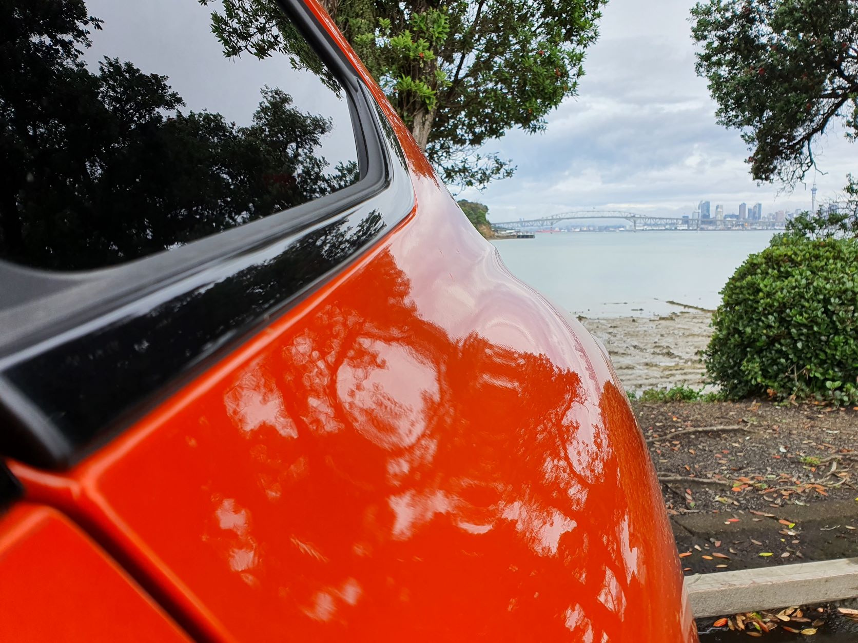 View from the rear corner of the Renault Arkana R.S Line, looking out over Auckland Harbour and Auckland City.