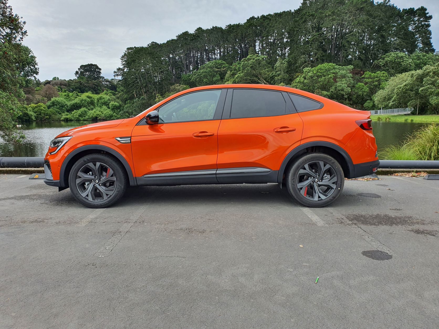 Side view of a Valencia Orange Renault Arkana R.S Line