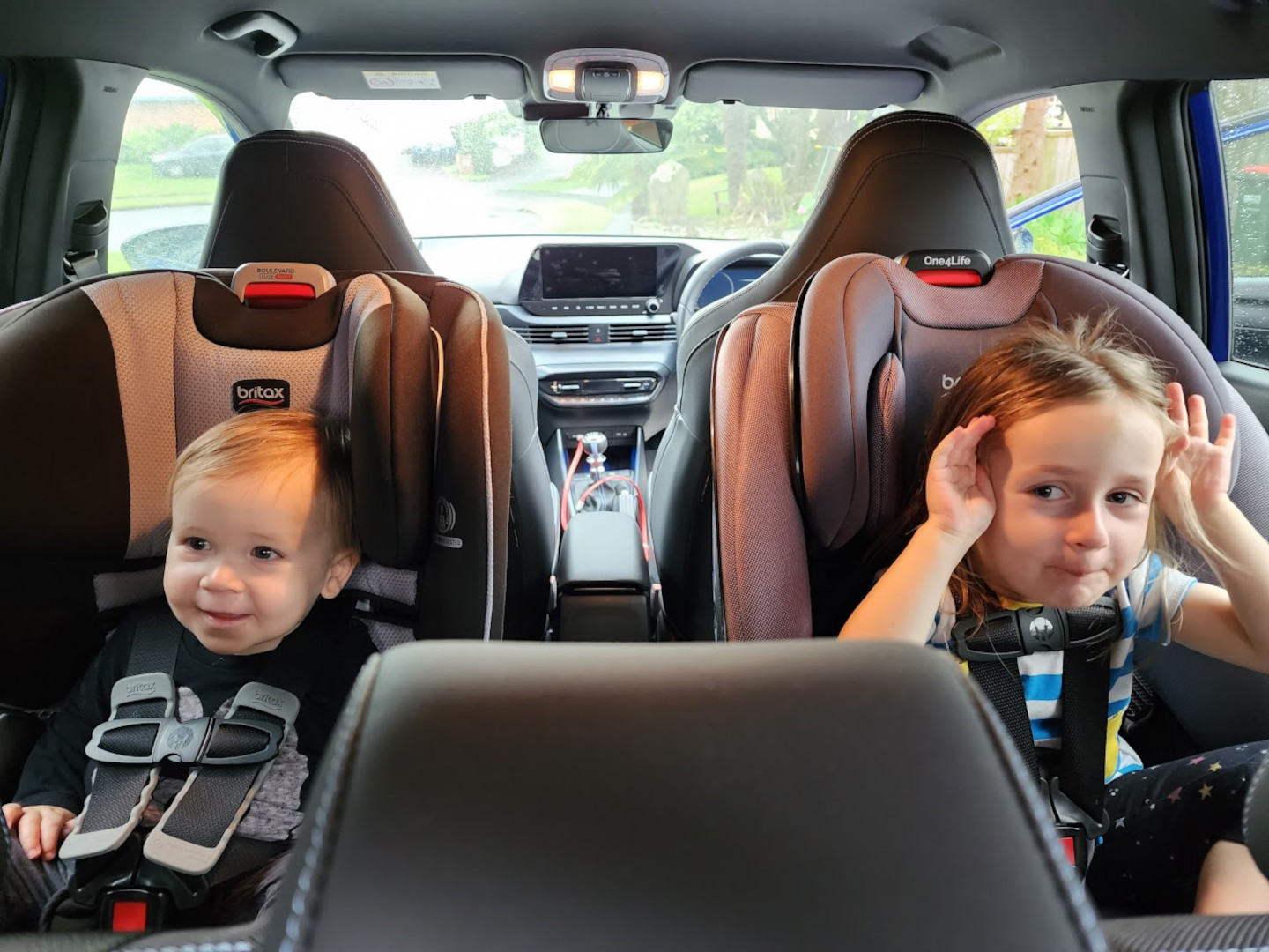 Two children in rear facing safety seats in the back of a Hyundai i20 N in New Zealand.