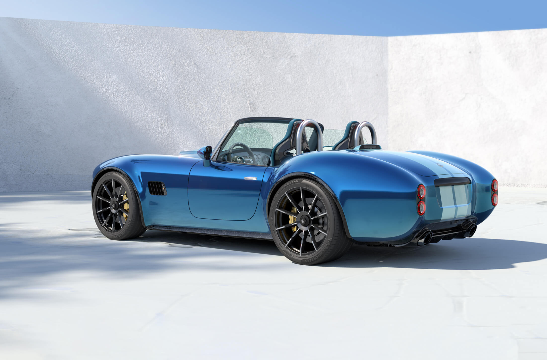 Rear three quarters view of the upcoming AC Cobra GT roadster in blue with white stripes