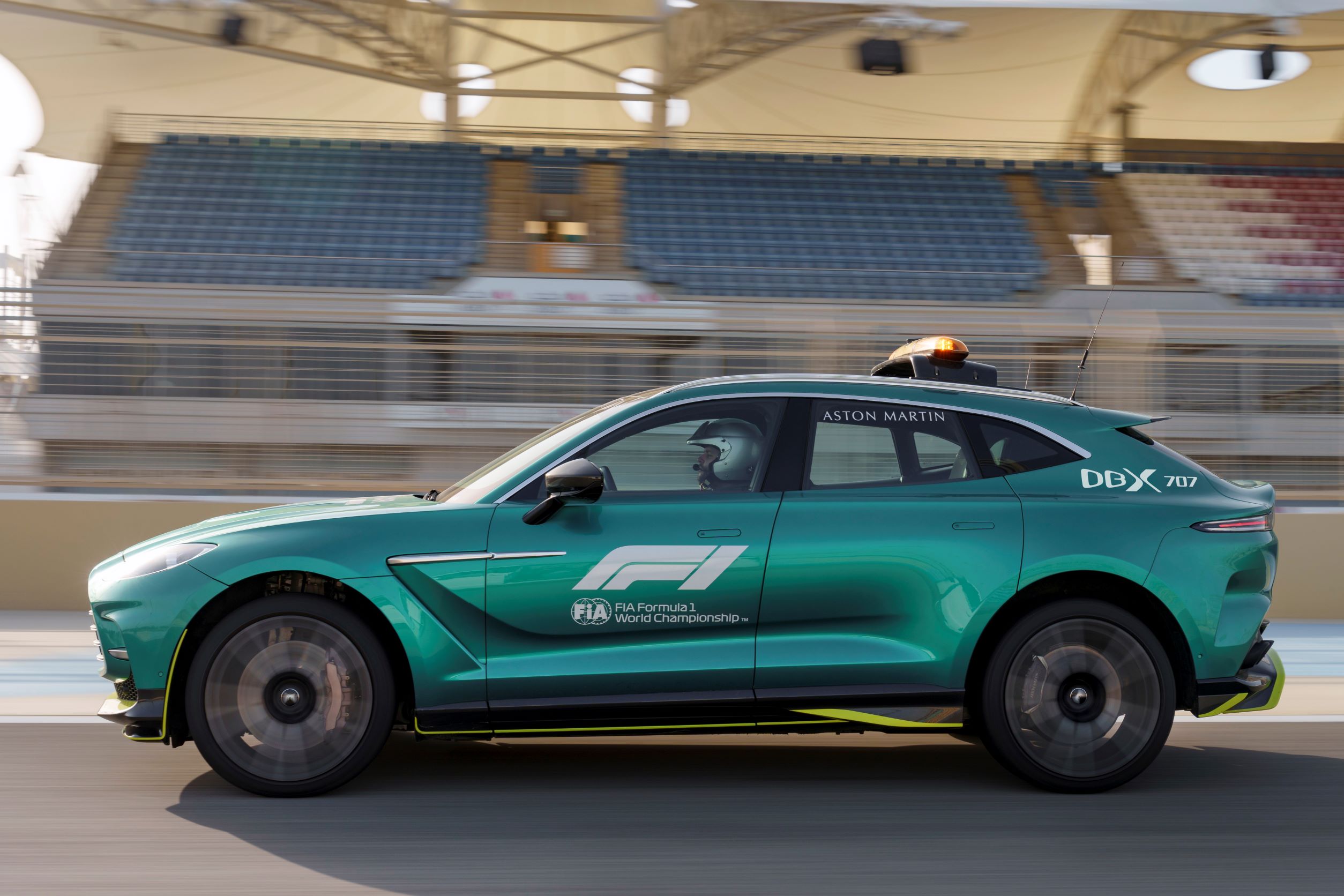 Side view of a green Aston Martin DBX707 F1 Medical Car in motion