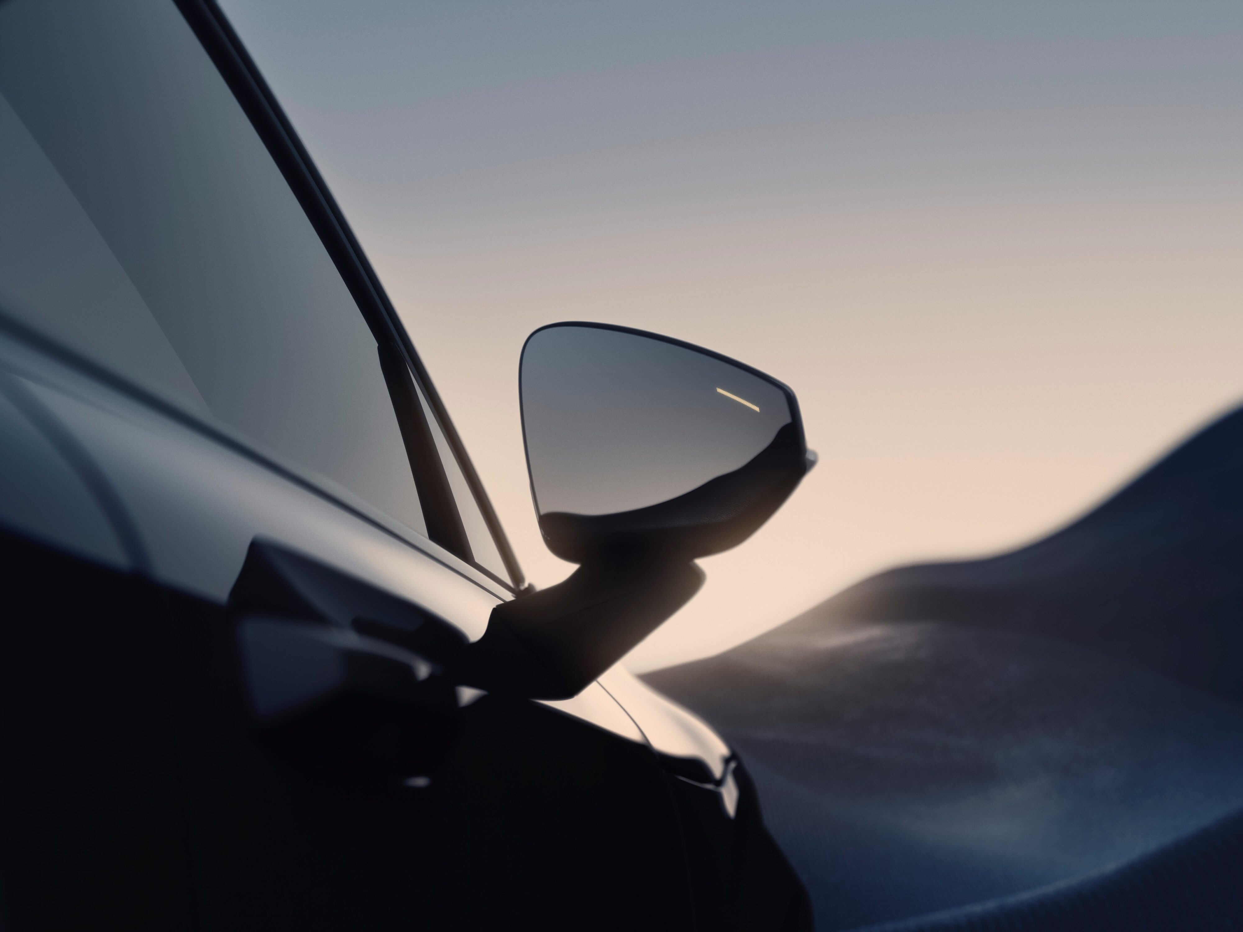 Teaser image of the right side view mirror on the new Volvo EX30 SUV