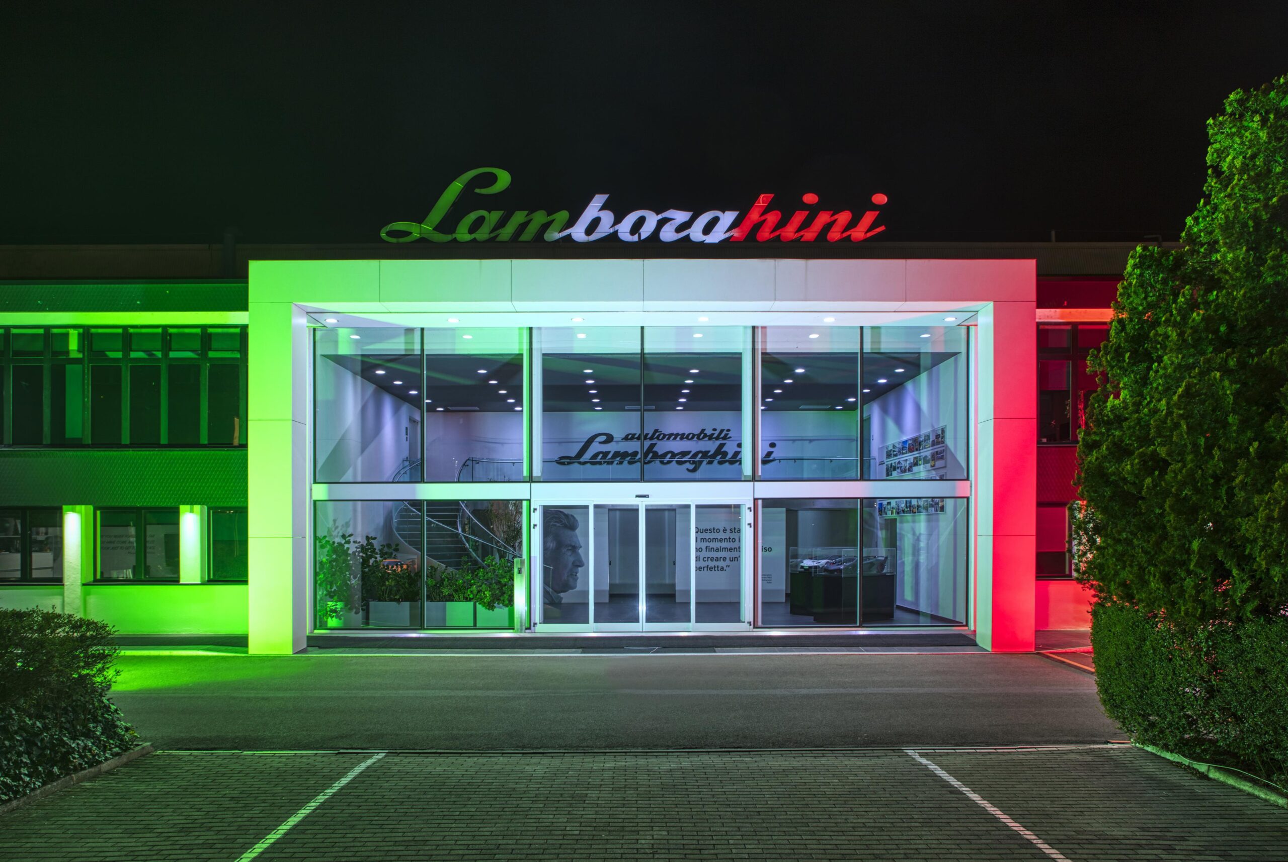 An exterior shot of Lamborghini's HQ in Italy lit up in the colours of the Italian flag, green, white and red.