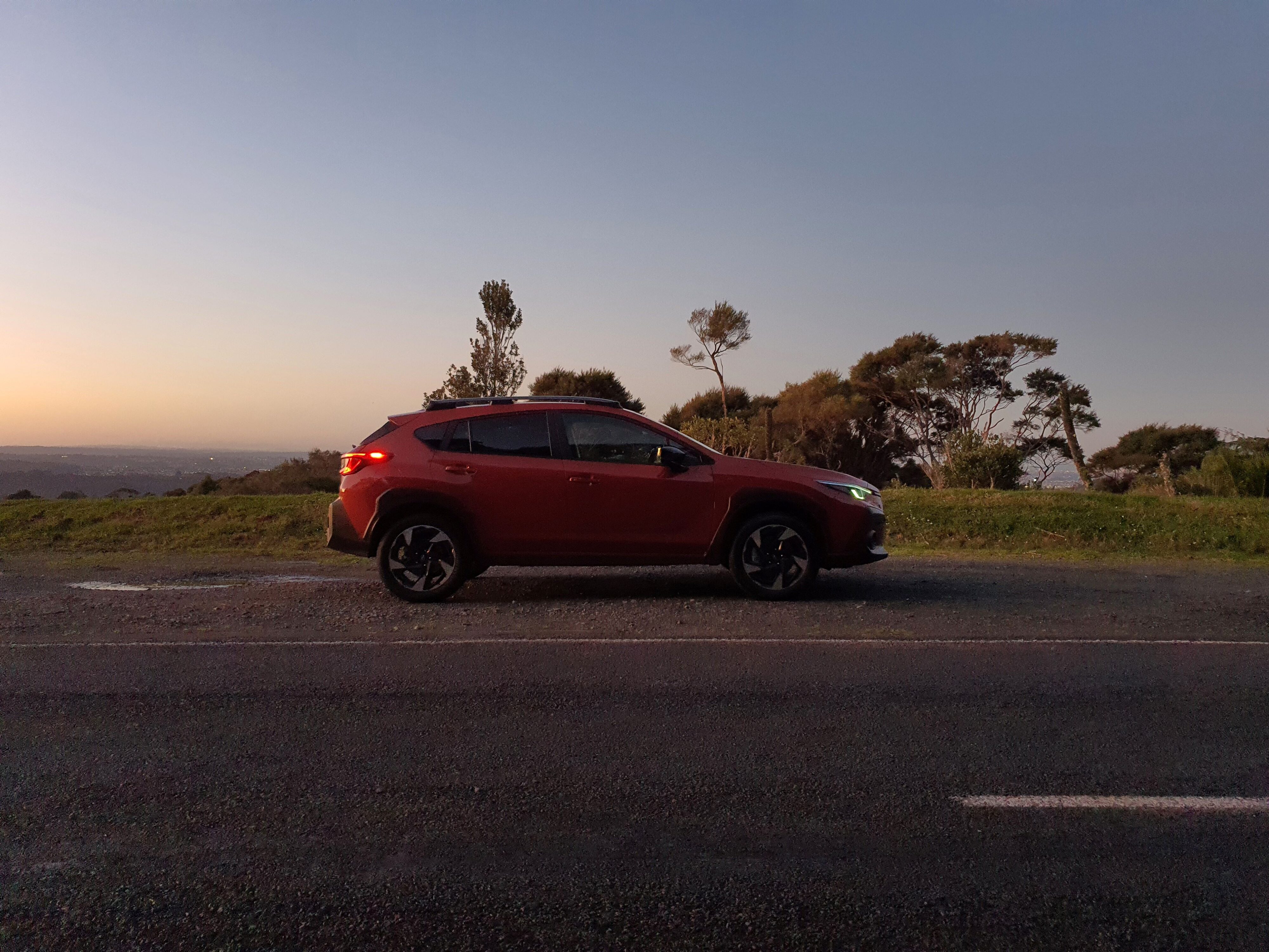 Side view of a 2023 Subaru Crosstrek Petrol Premium in Sun Blaze Pearl. Photo taken at sunset.