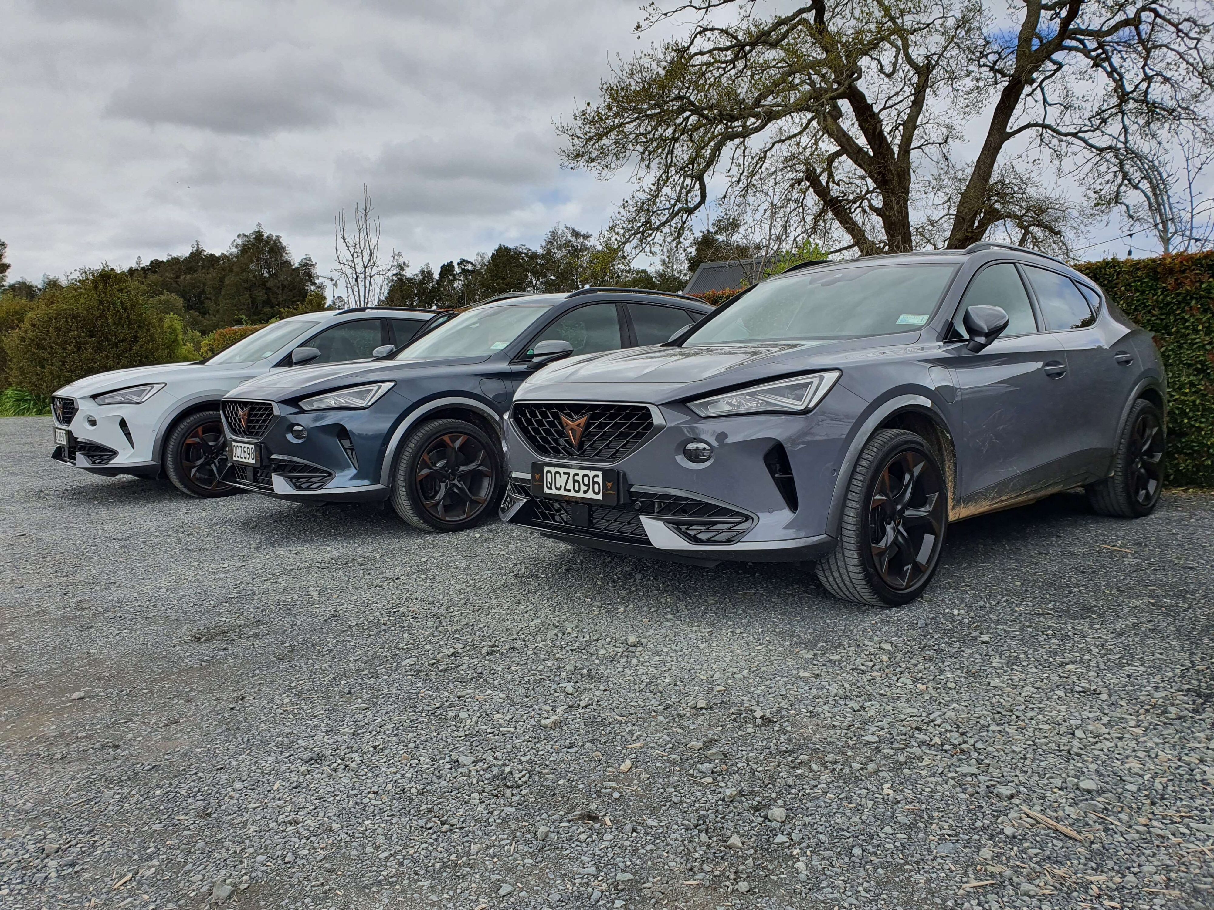 A photo of three 2023 Cupra Formentor V e-Hybrid's in a row. Painted in White, Grey and Tech respectively.