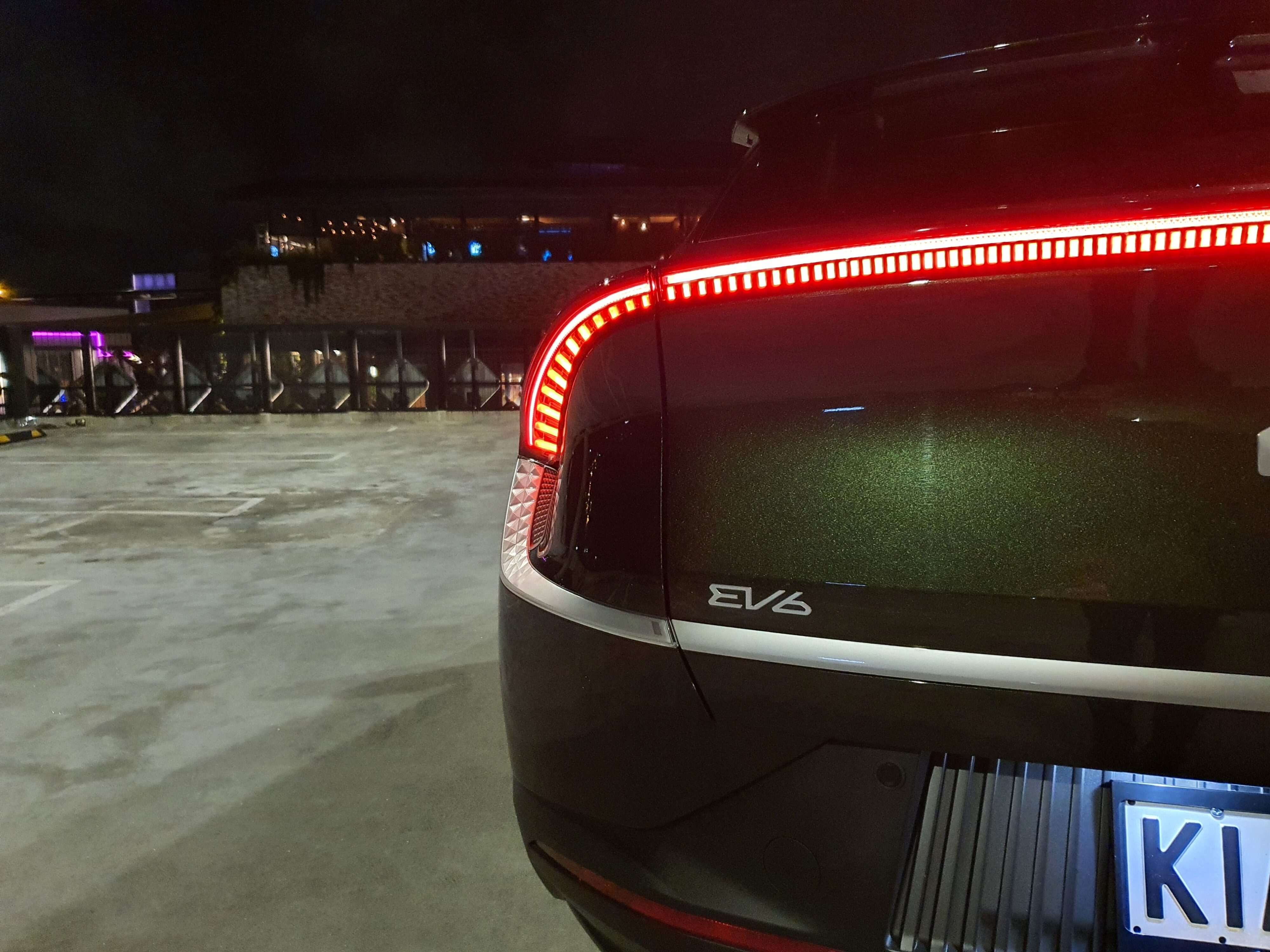 Close-up of the EV6 badge and light bar on the rear of a 2023 Kia EV6 Air Long Range in Deep Forest Green.