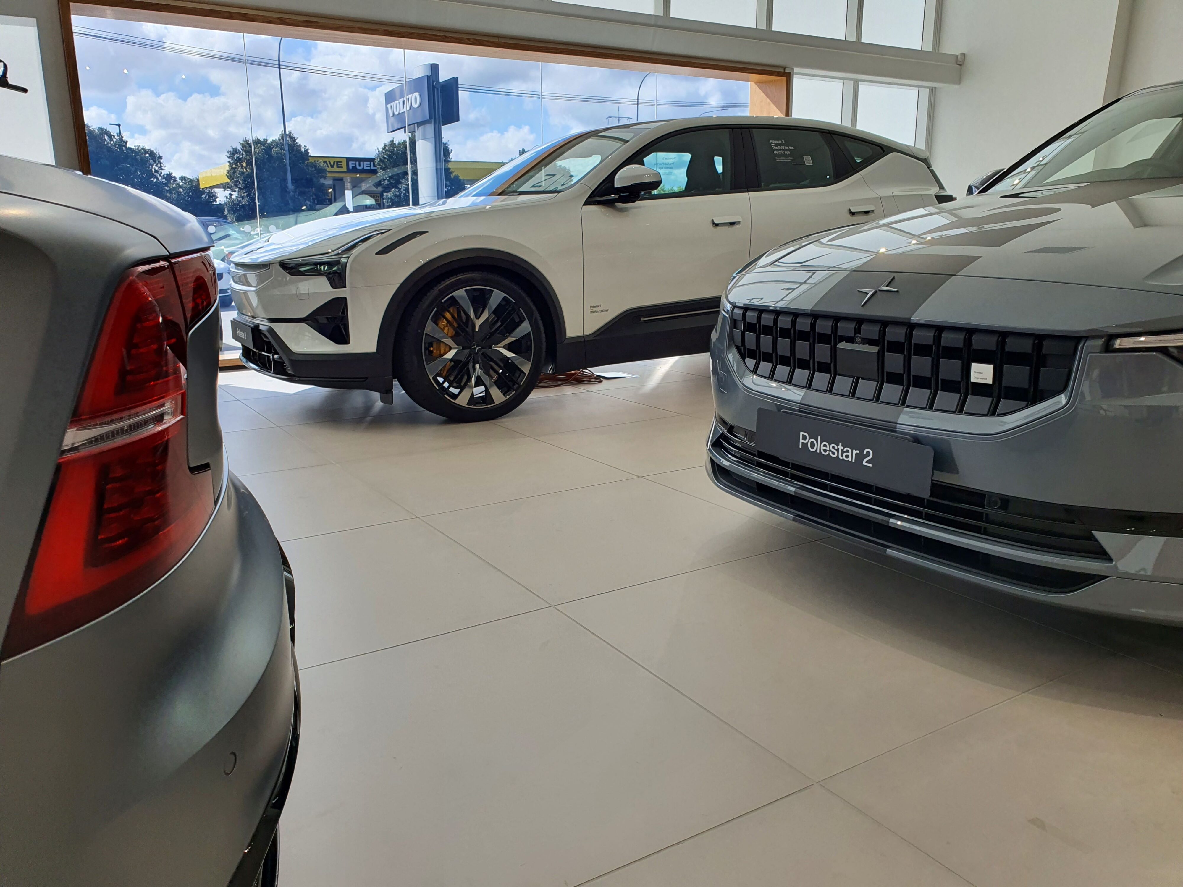 A photo with a Gray Polestar 1 in the foreground, a Gray Polestar 2 on the right and a White Polestar 3 in the background.