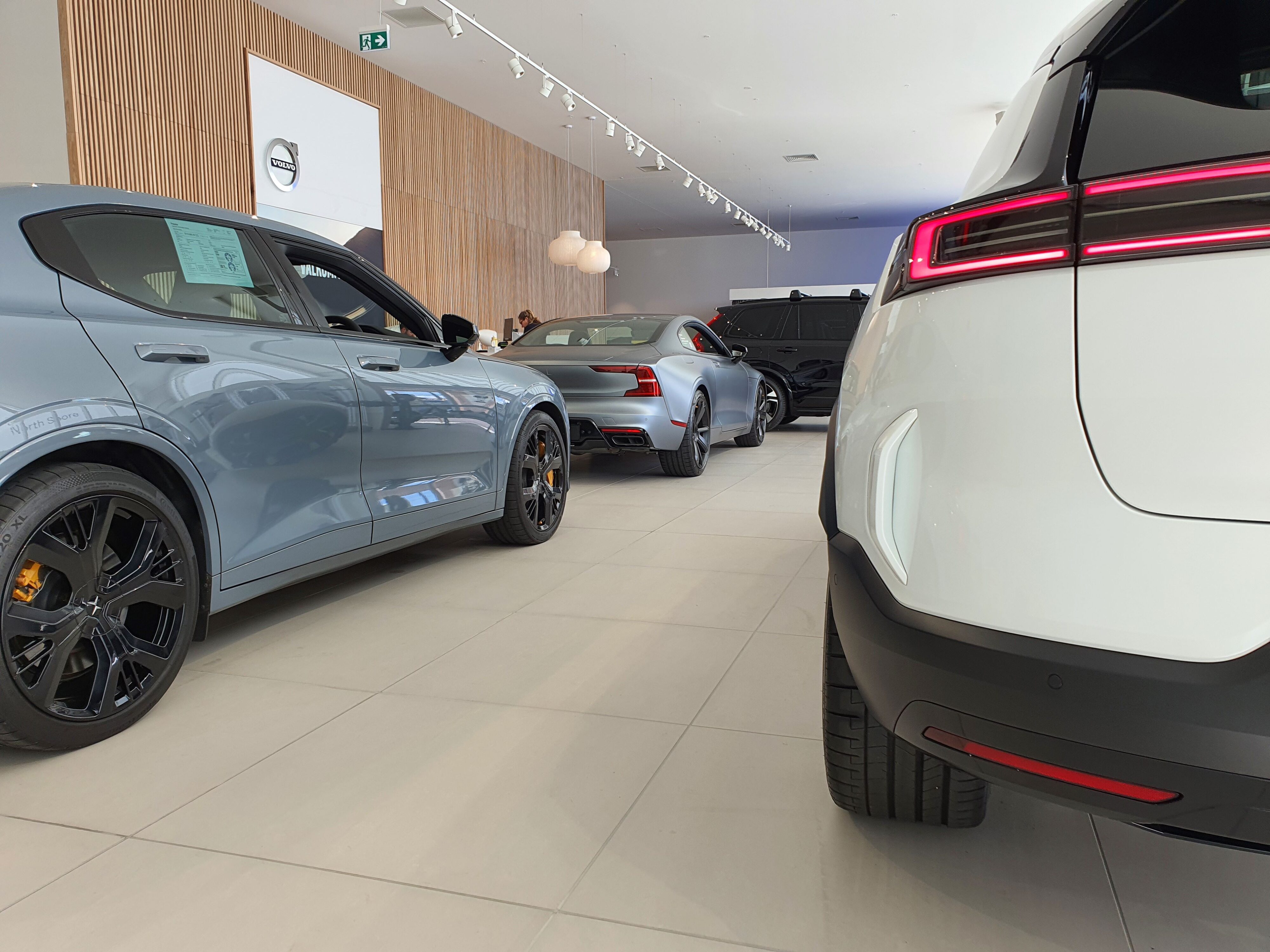 A photo of a Polestar 2 on the left in Gray, a Polestar 3 on the right in White and a Polestar 1 in the background in Gray.