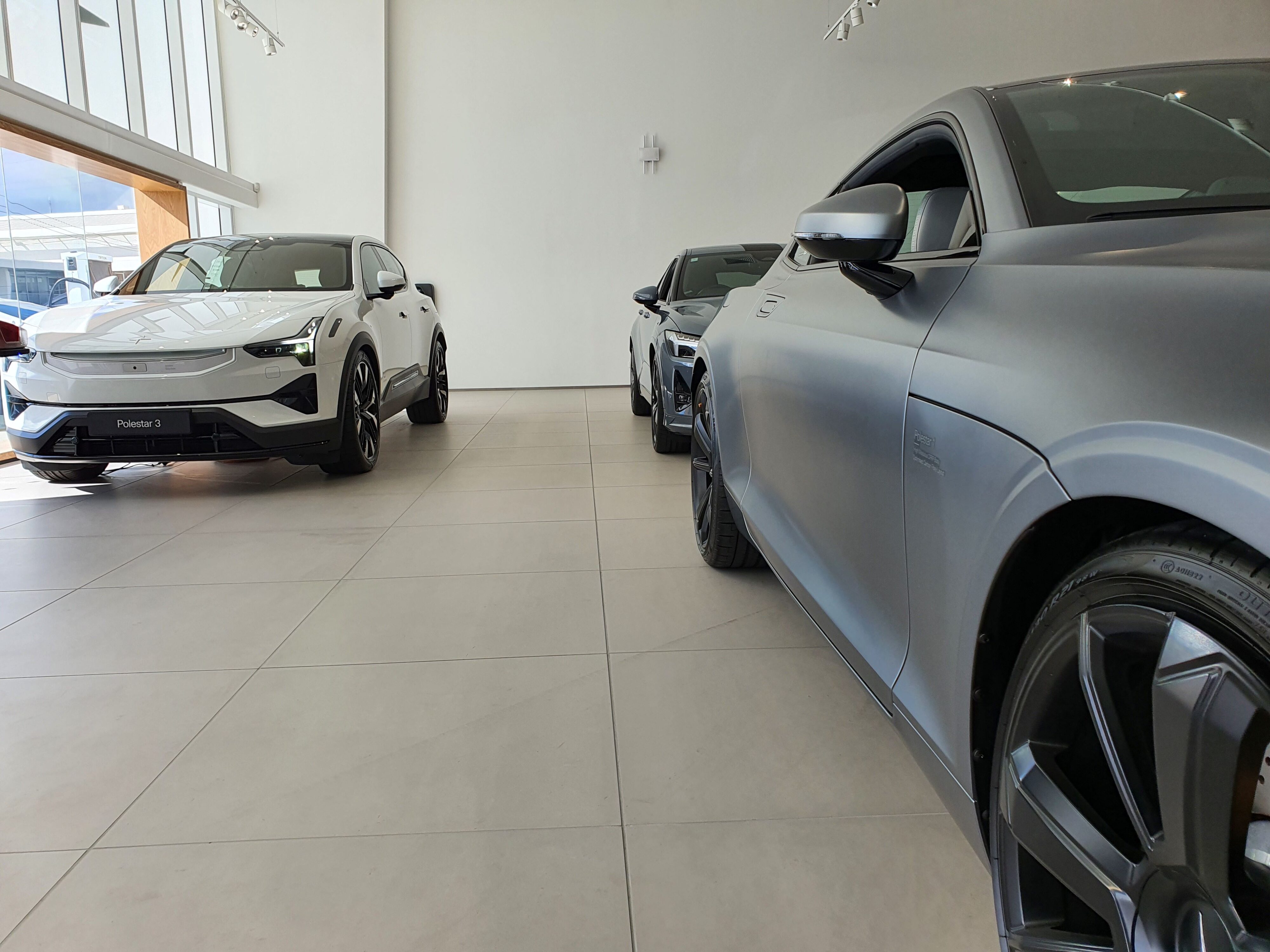 A Gray Polestar 1 on the right of the photo followed by a Gray Polestar 2 on the right side, joined by a White Polestar 3 on the left.