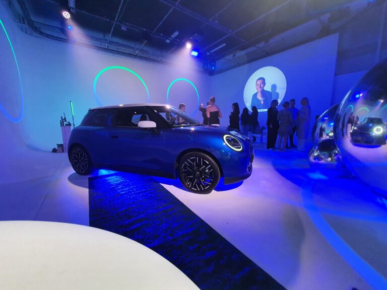 Photo of a 2024 MINI Cooper S E in a studio with low lighting.