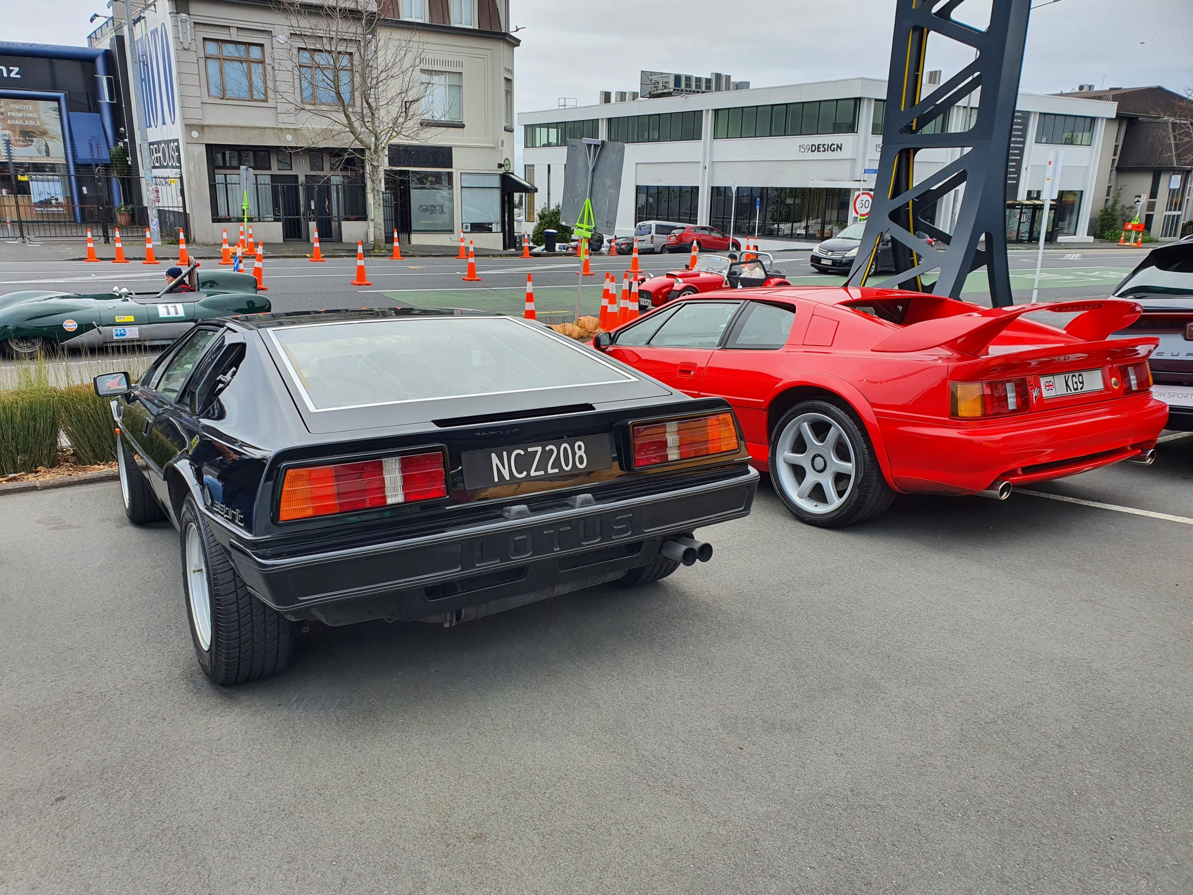 Two Lotus Esprits, a black Esprit Turbo on the left and a red Esprit V8 on the right.