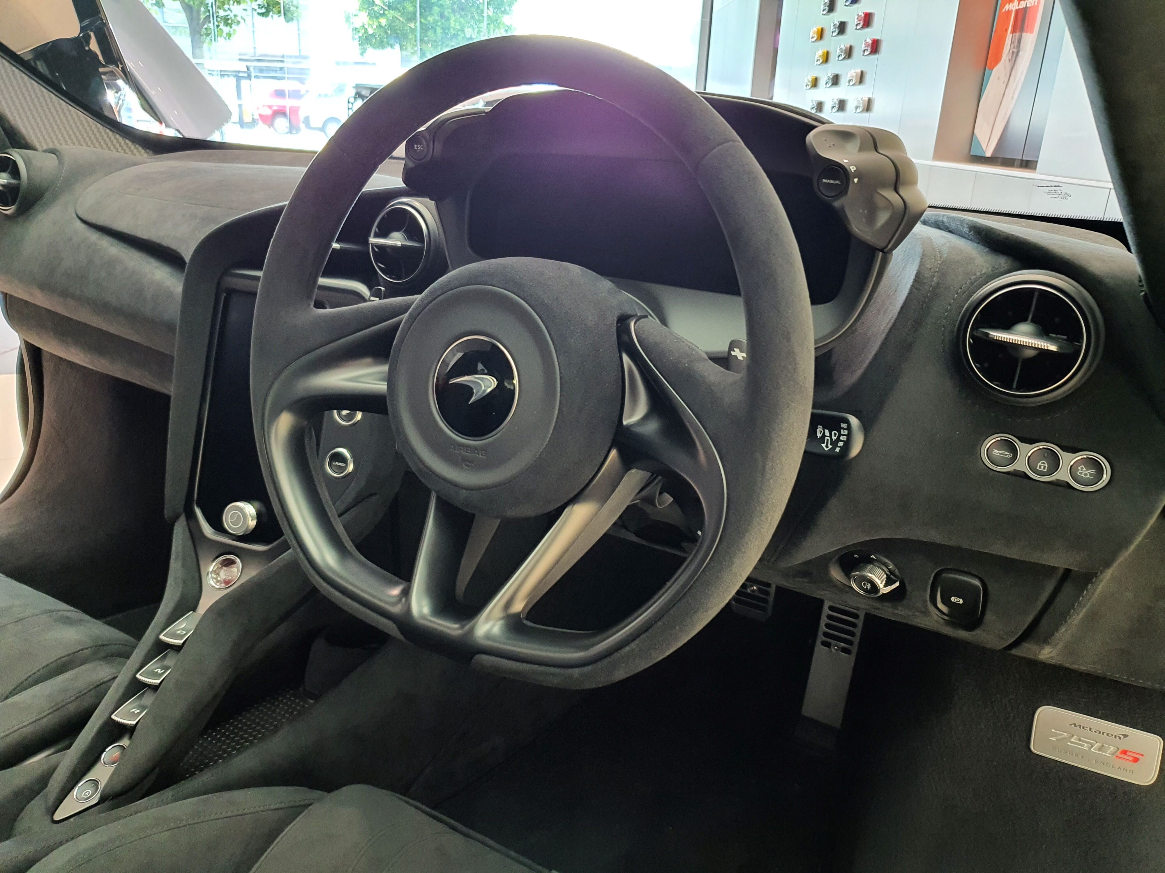 AN interior shot of the new McLaren 750S showing the steering wheel, gauge cluster and centre console.
