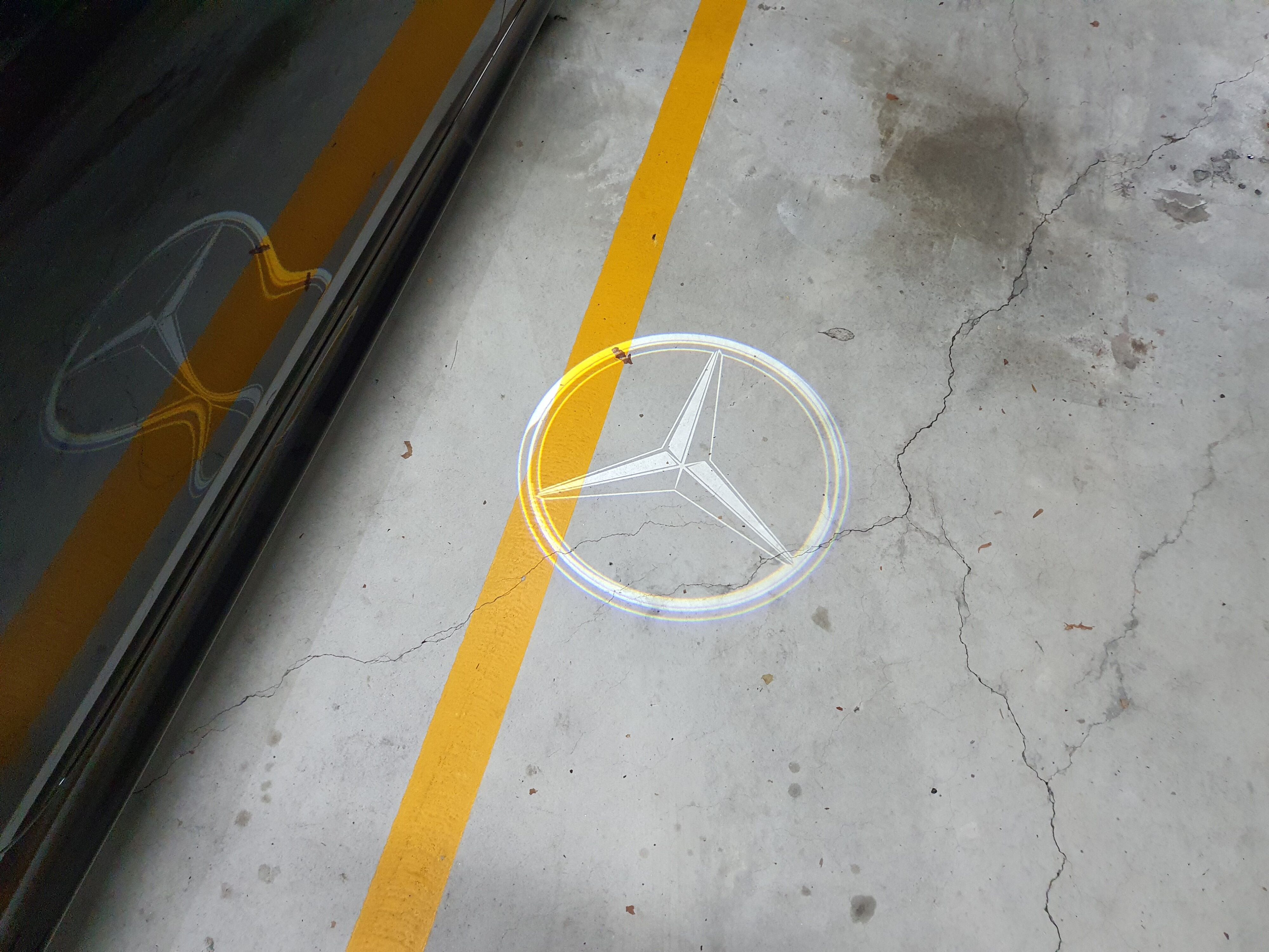 Mercedes-Benz tri start logo projected on to the ground from a 2024 Mercedes-Benz CLE300 4MATIC.