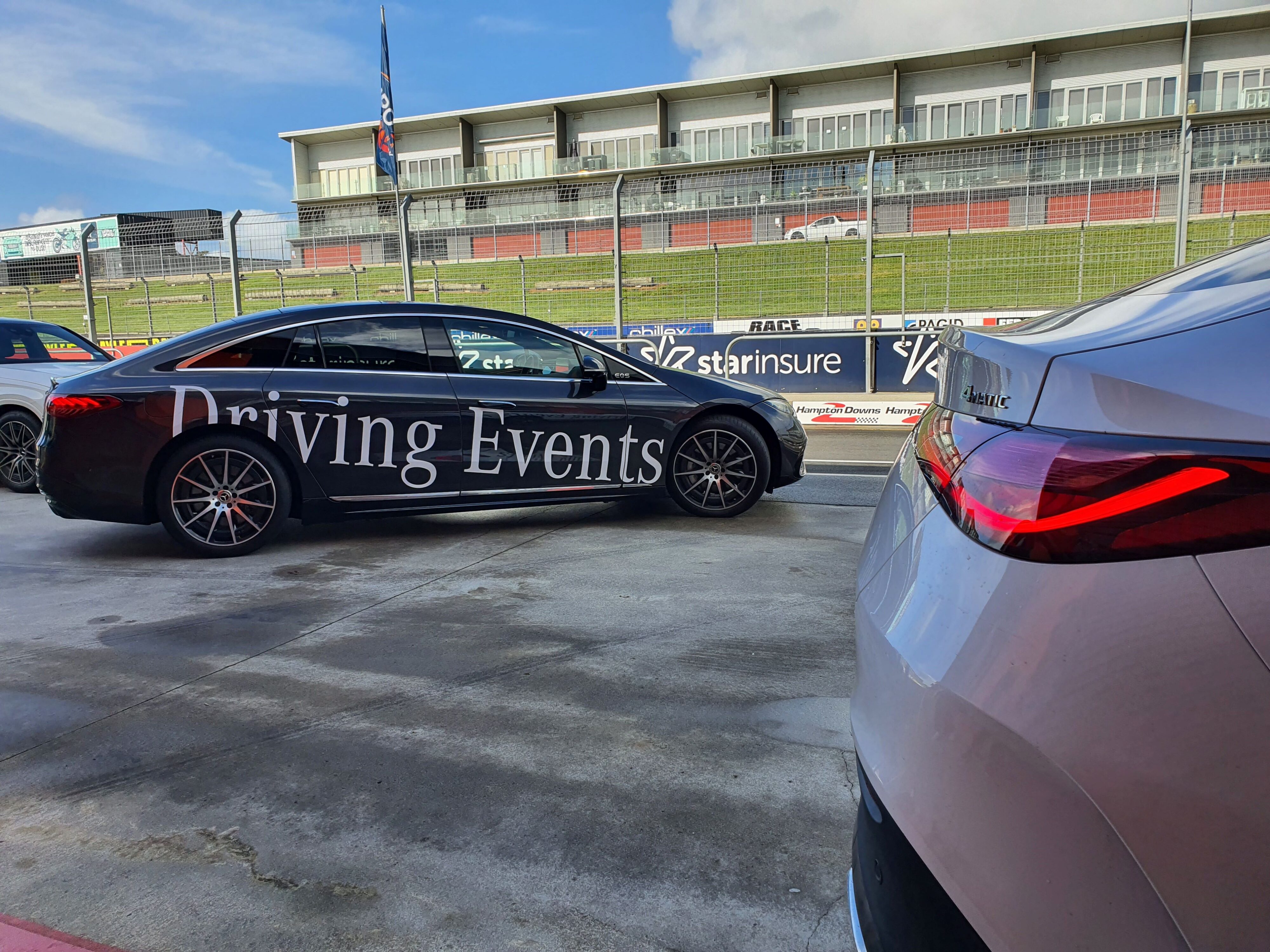 A Mercedes-Benz GLC43 AMG Coupe in the foreground with a Mercedes-Benz EQS sedan in the background at the Mercedes-Benz Driving Event at Hampton Downs in August 2024.