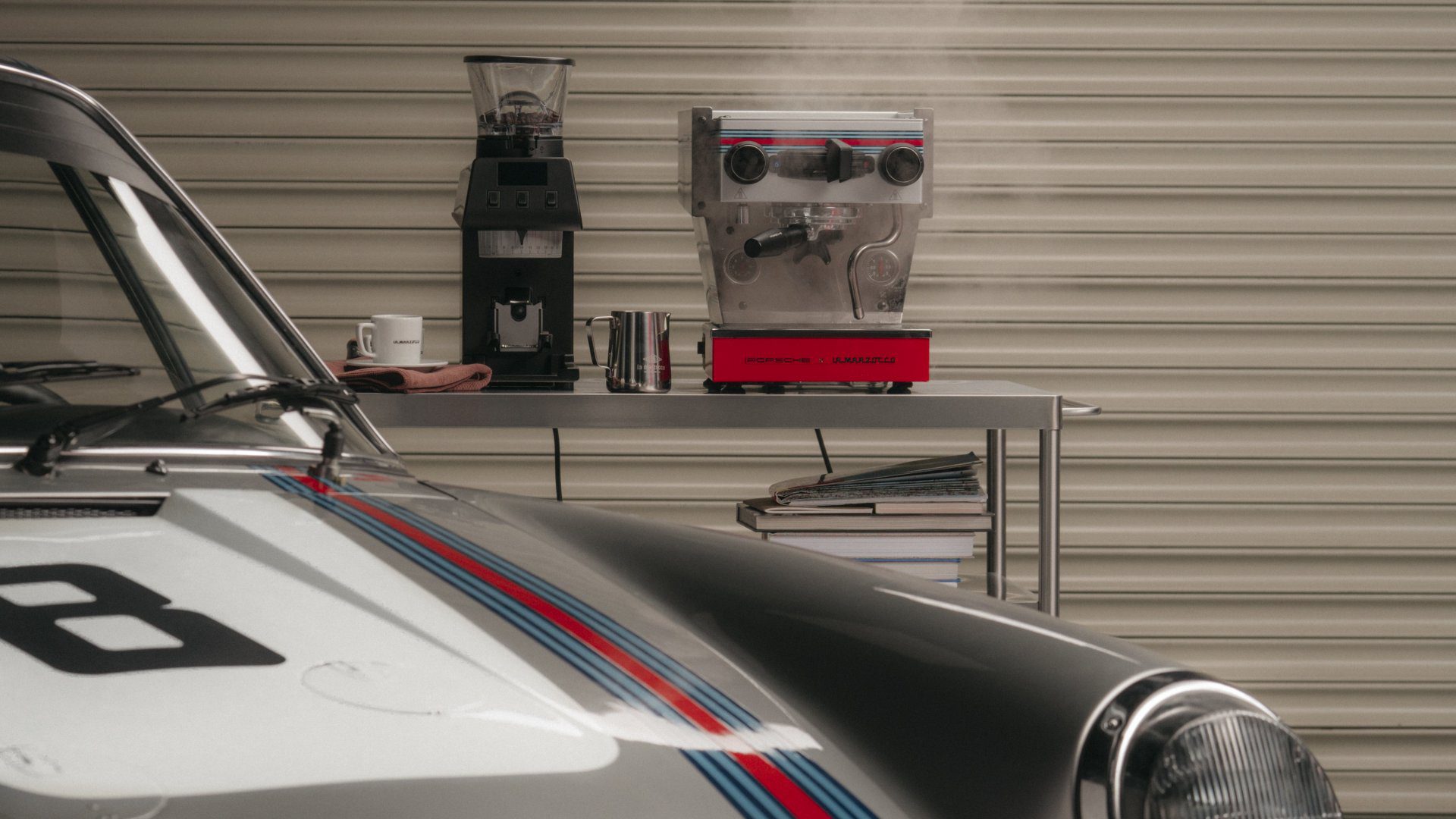Porsche 911 with a La Marzocco Linea Micra 911 coffee machine in the background.