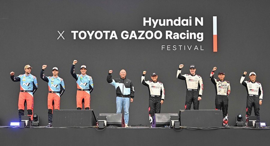 Racing drivers from Hyundai N and Toyota Gazoo Racing stand together on stage.