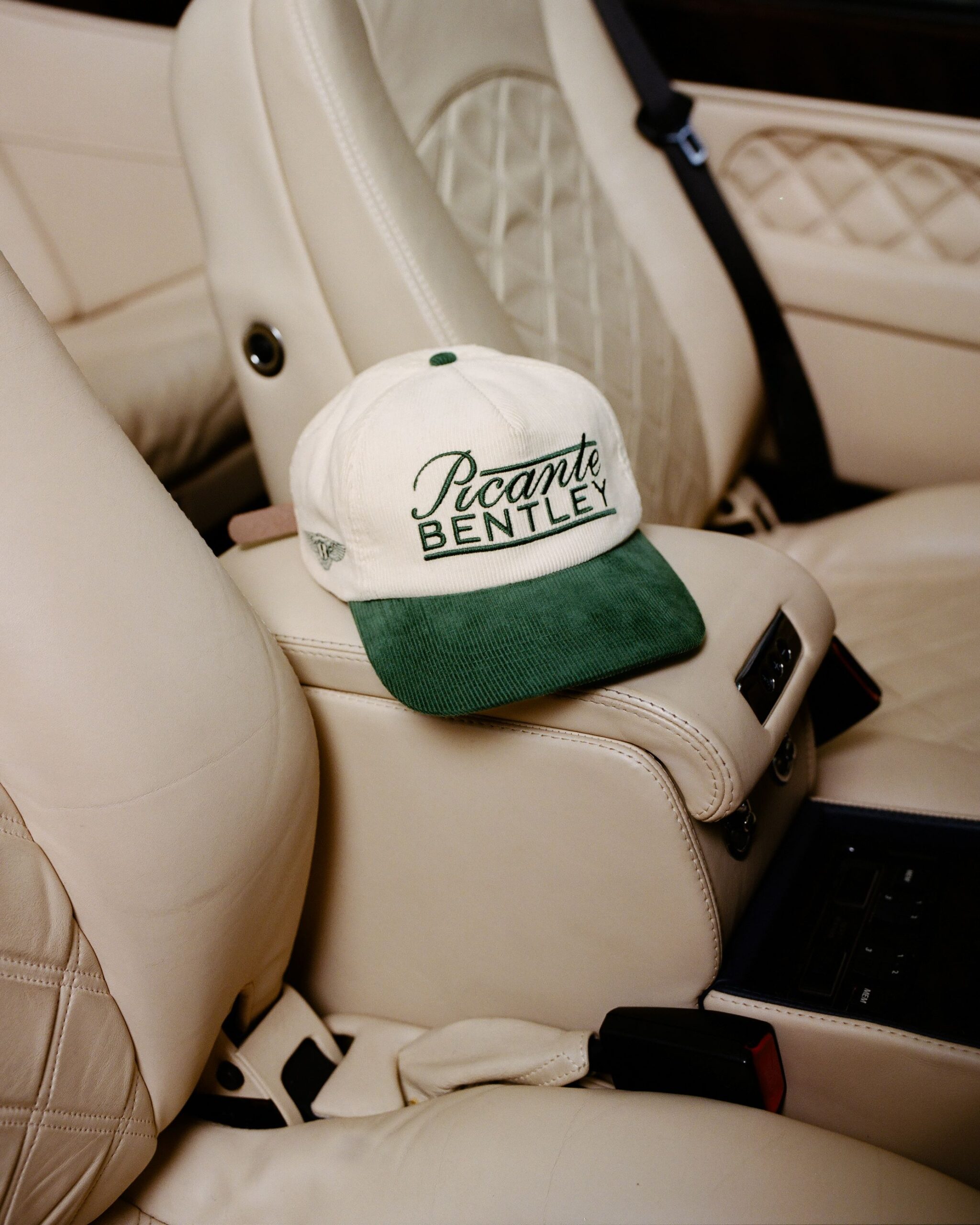 A photo of a Bentley and Picante baseball hat inside a classic Bentley.