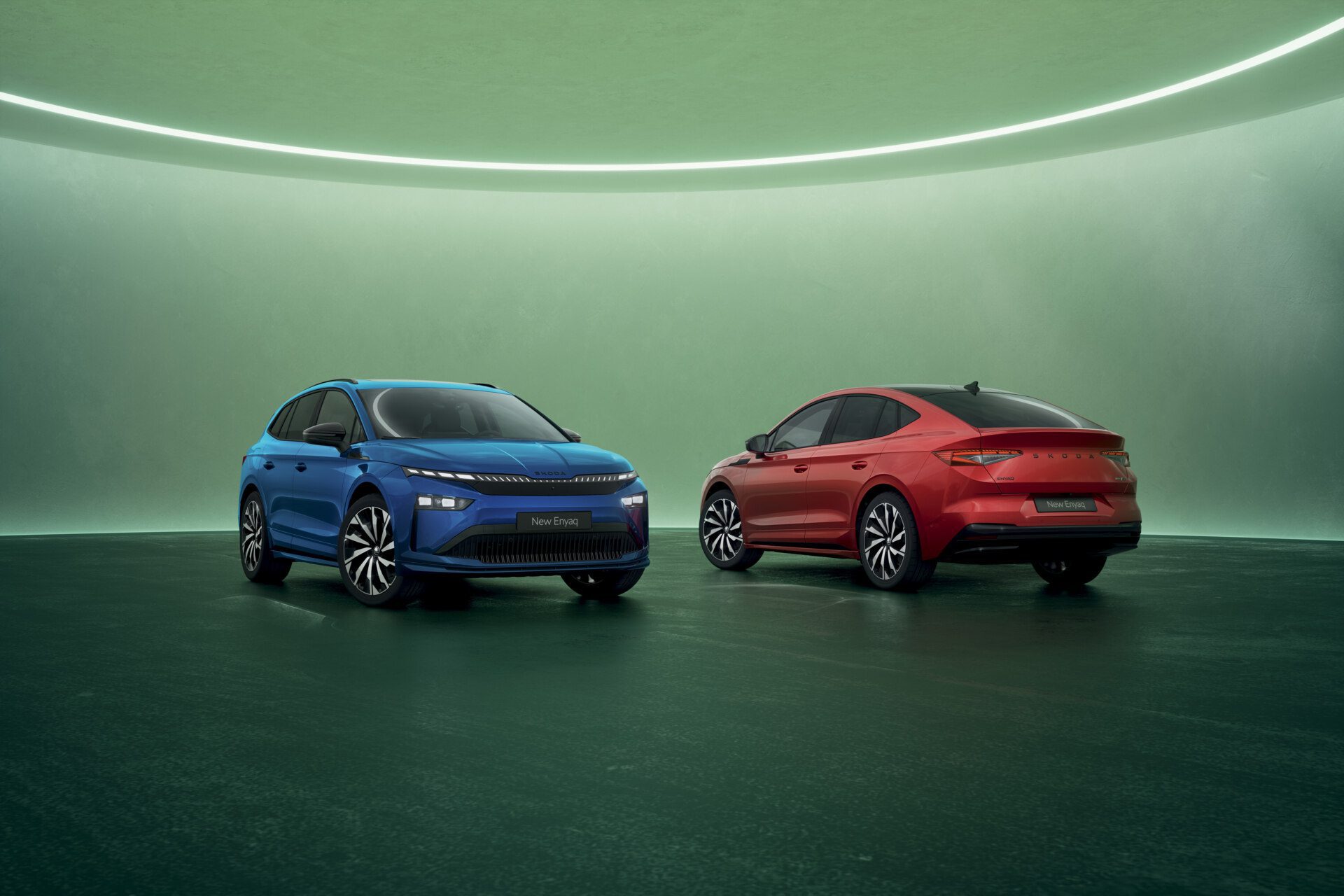 A photo of a new Skoda Enyaq and new Enyaq Coupe pictured in blue and red respectively.