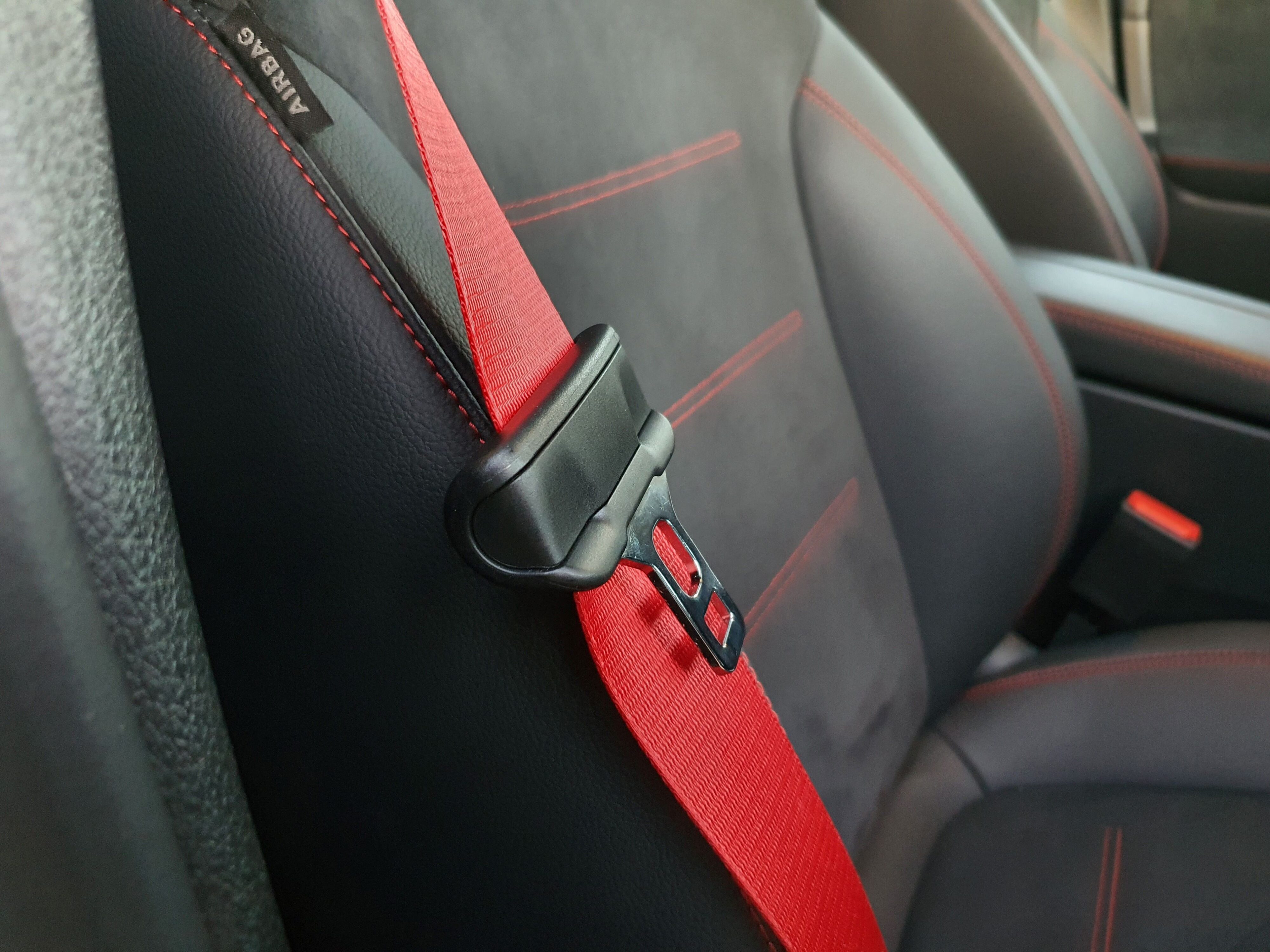 Red seatbelts and highlight stitching on the interior of a 2024 Mercedes-AMG GLB 35 4MATIC in Black.