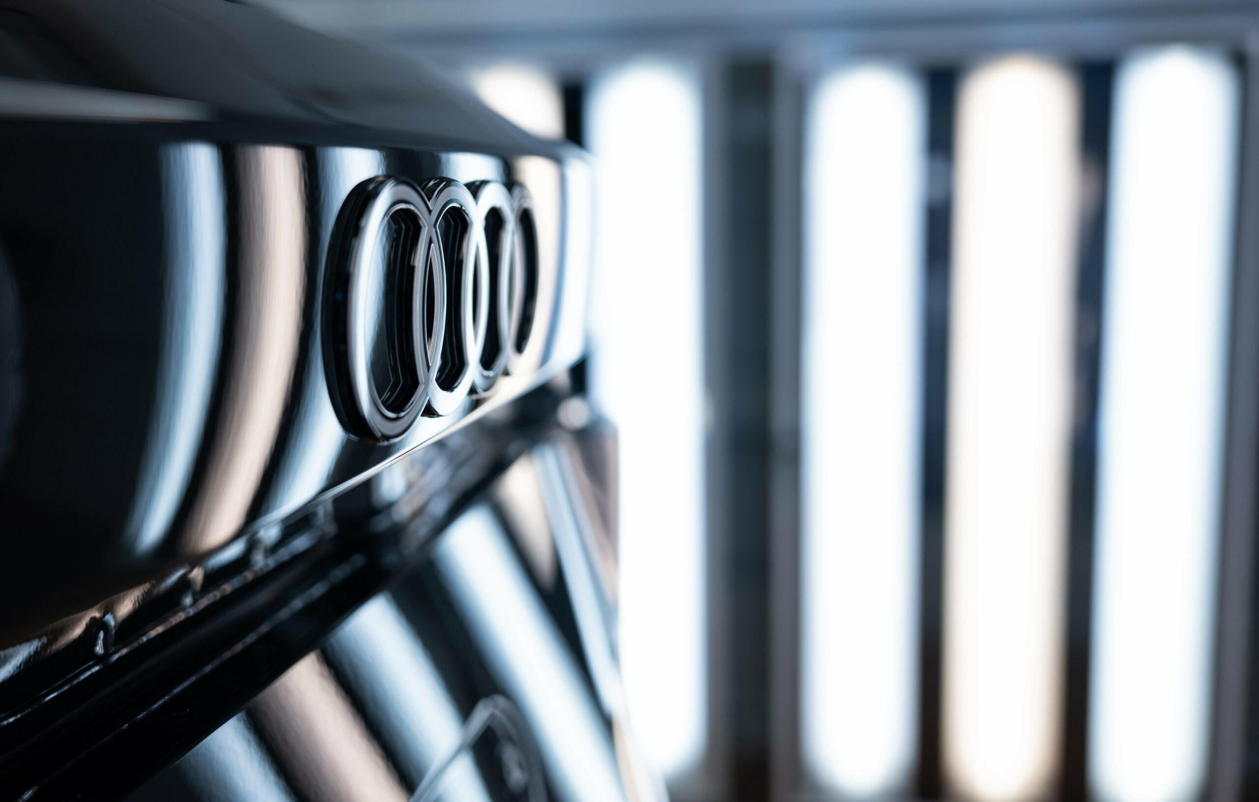 An image of an Audi badge on the nose of their vehicle in a factory.