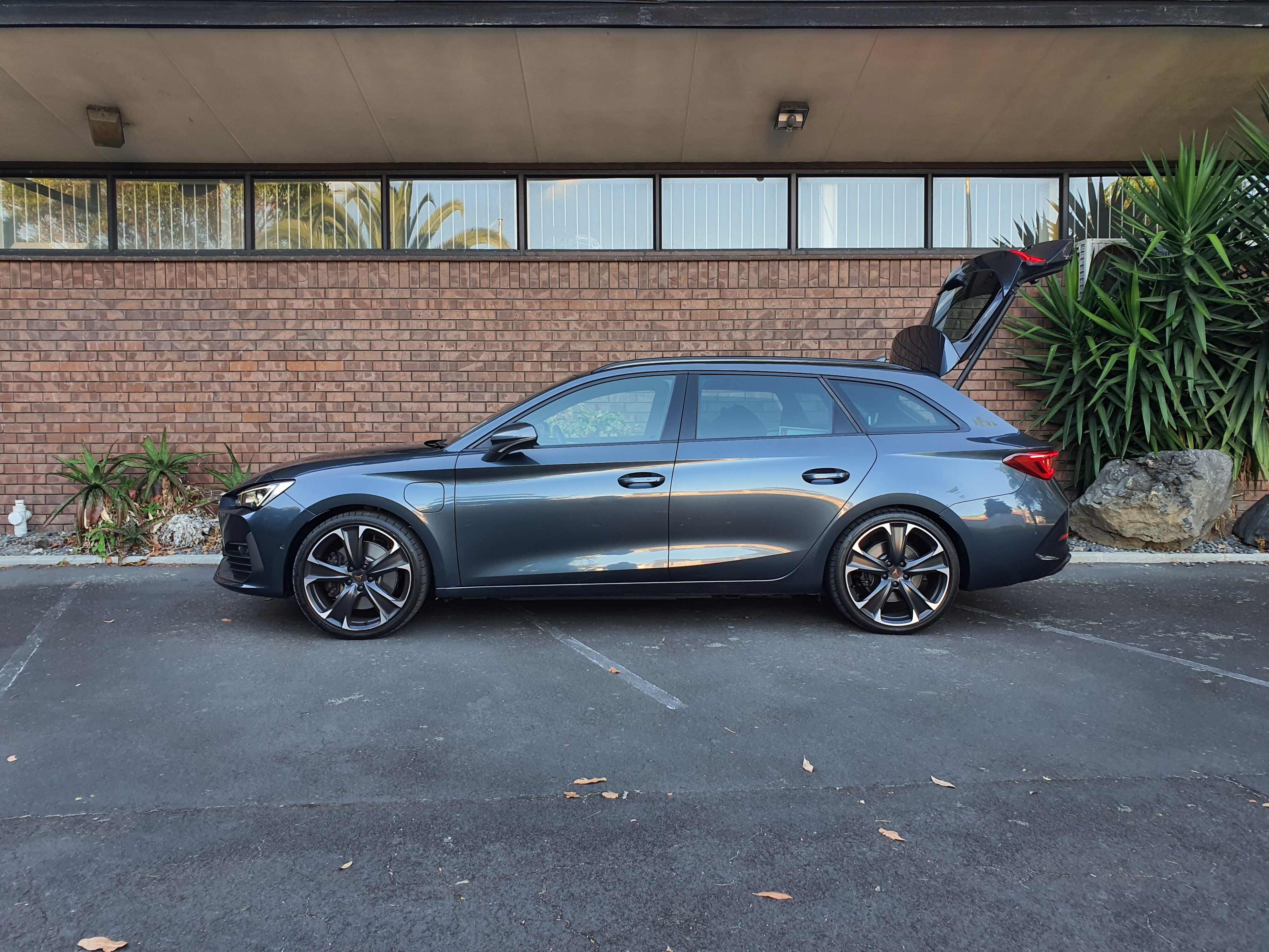 Side on view of a 2024 Cupra Leon V Sportstourer -HYBRID in Magnetic Tech.