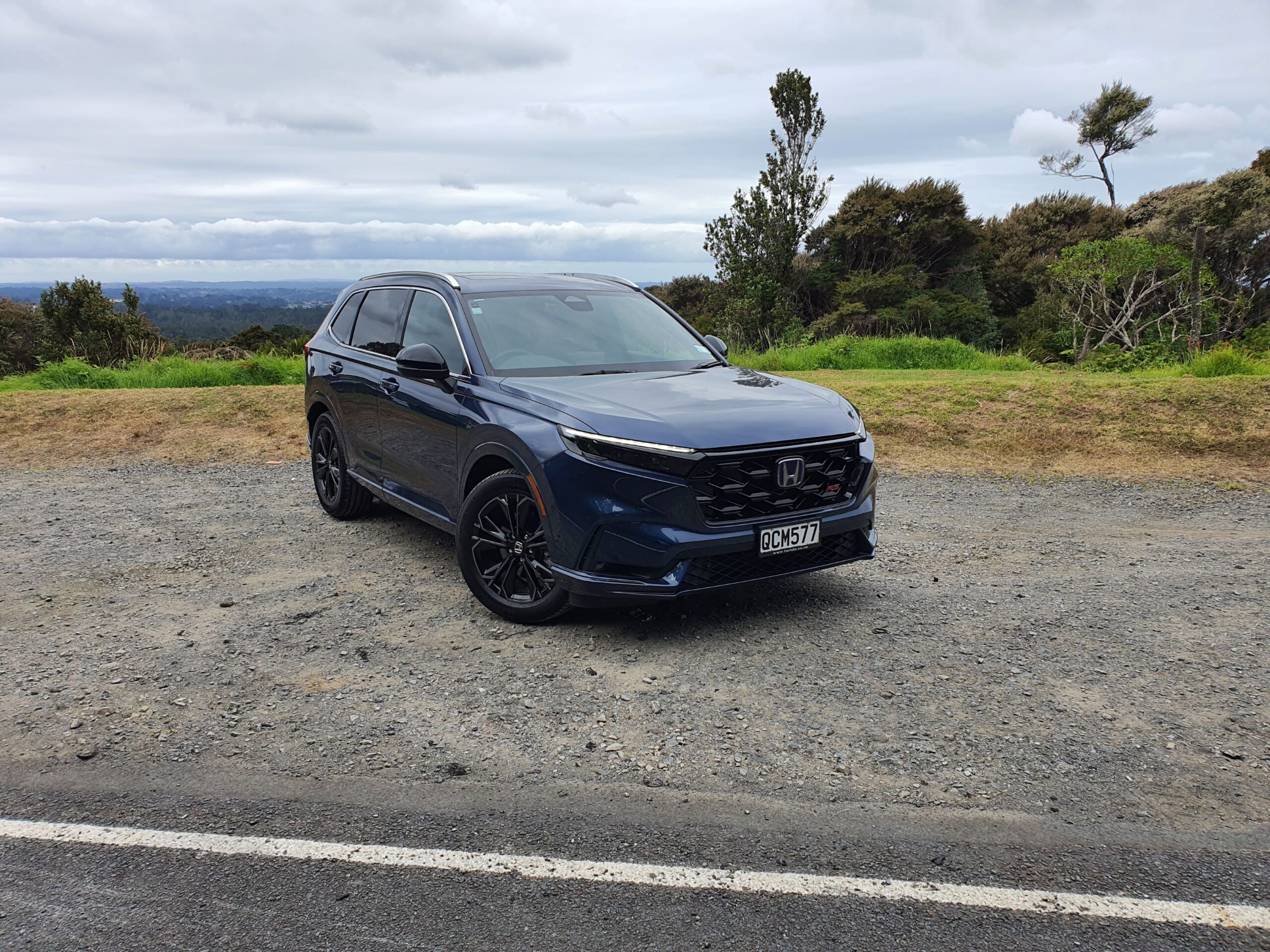 Front three quarters view of a 2024 Honda CR-V RS e:HEV in Canyon River Blue Metallic.