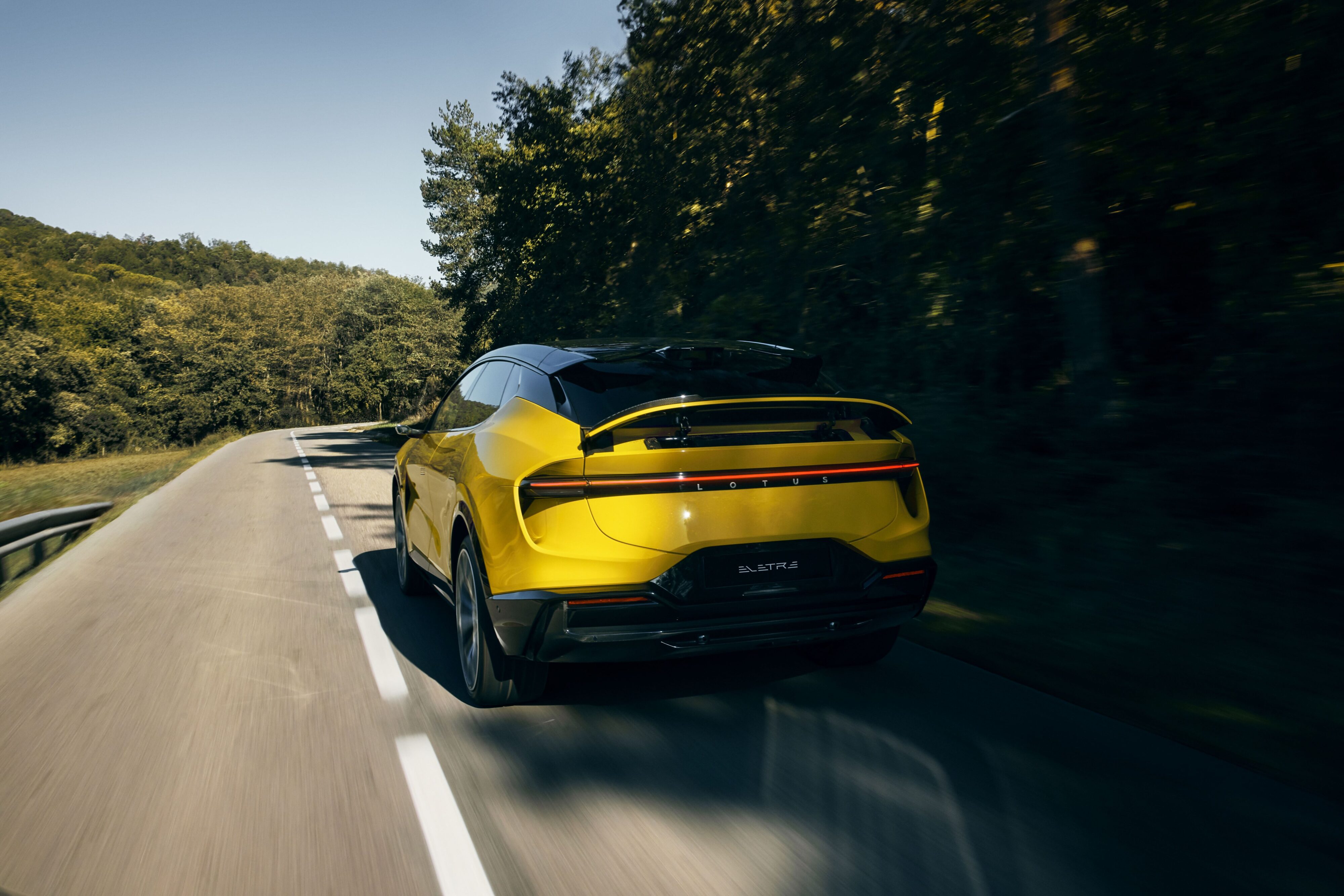 Rear three quarters of a Solar Yellow Lotus Eletre S in motion.