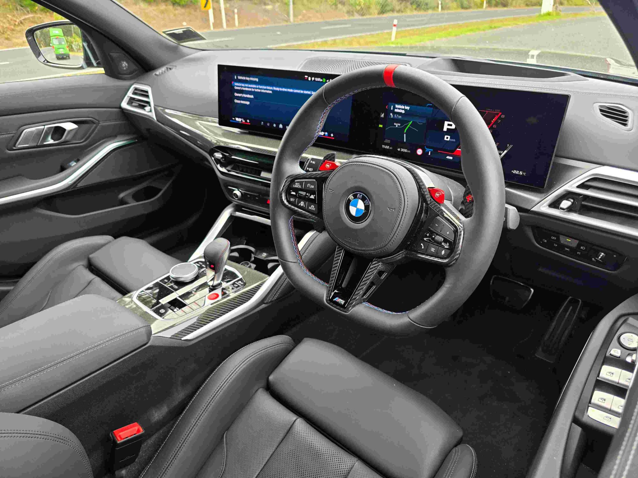 Luxurious BMW M3 Competition Touring interior with a curved digital display and sporty M seats.