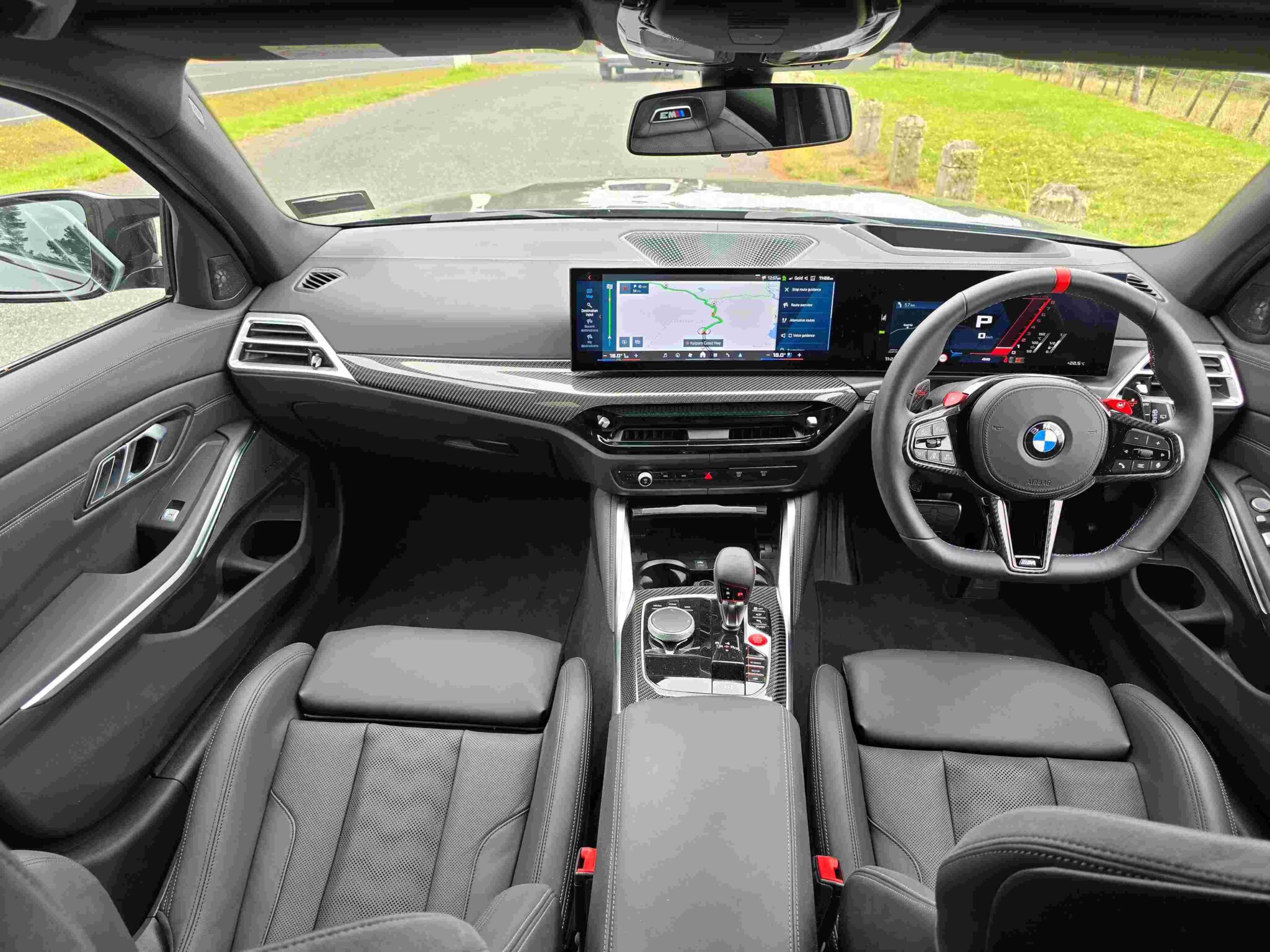 Luxurious BMW M3 Competition Touring interior with a curved digital display and sporty M seats.