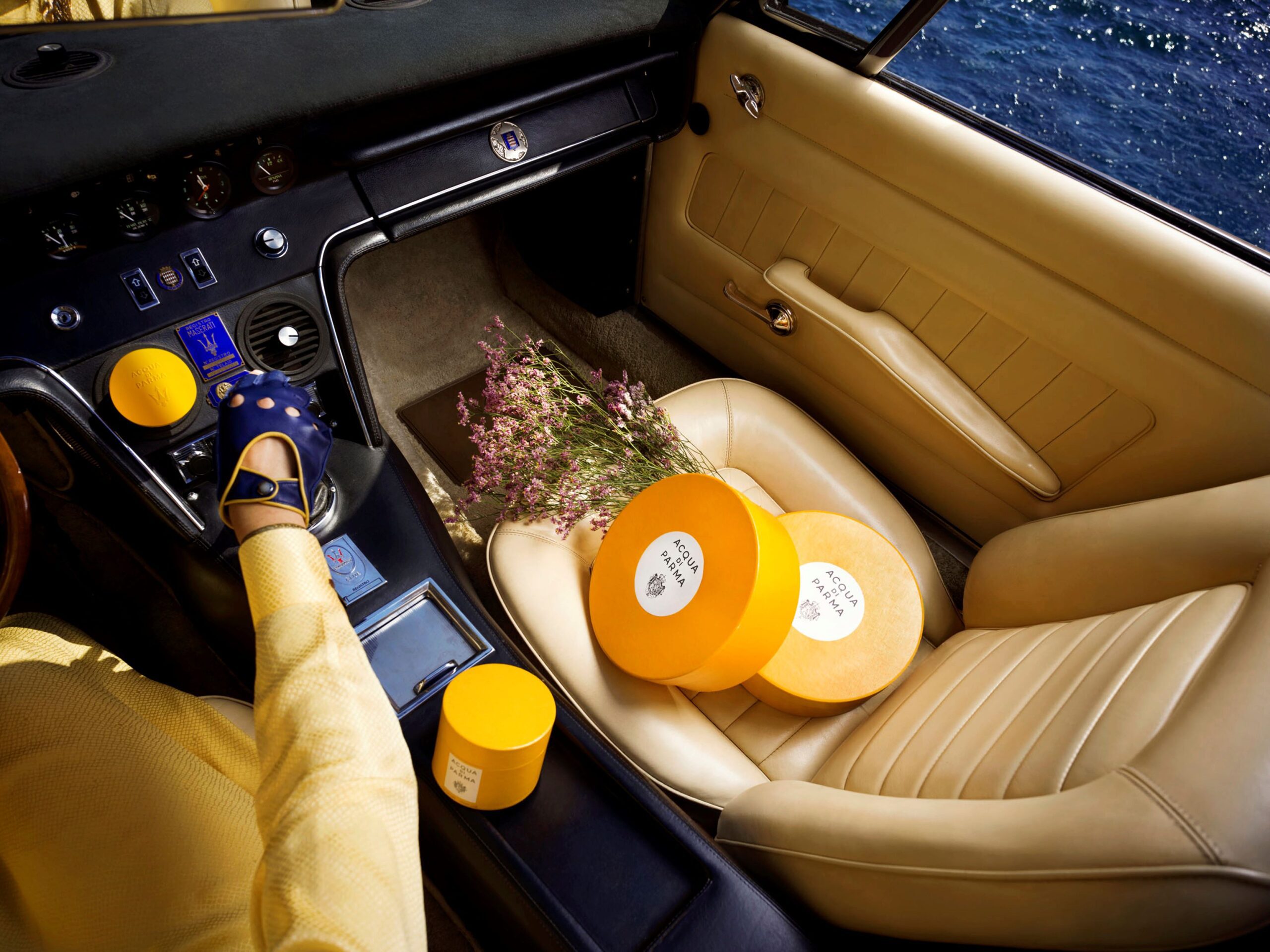 A phot of the Acqua di Parma x Maserati collection photographed inside a Maserati Ghibli Spyder.