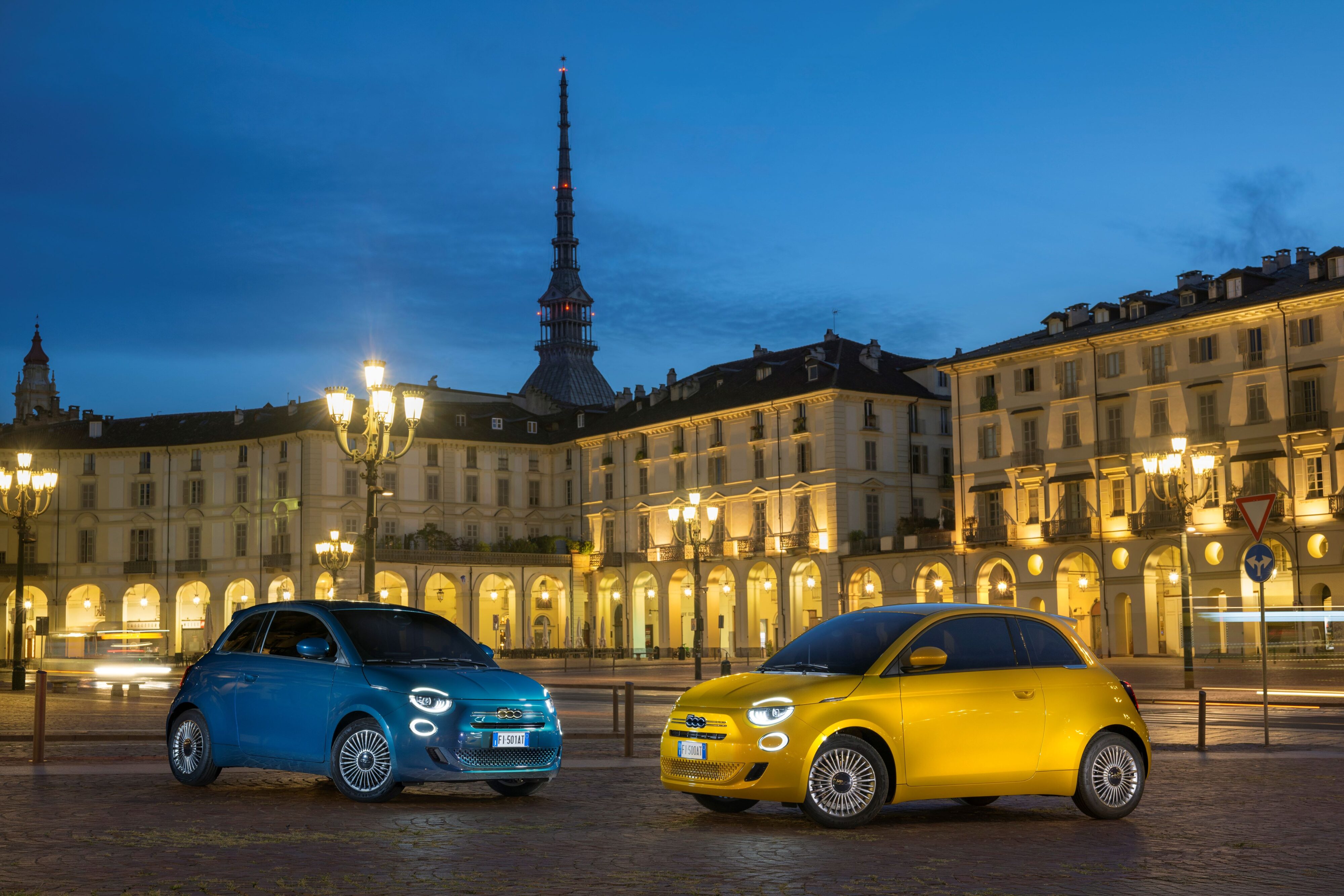 A photo of two new Fiat 500 Hybrids, one in yellow (right), one in blue (left).