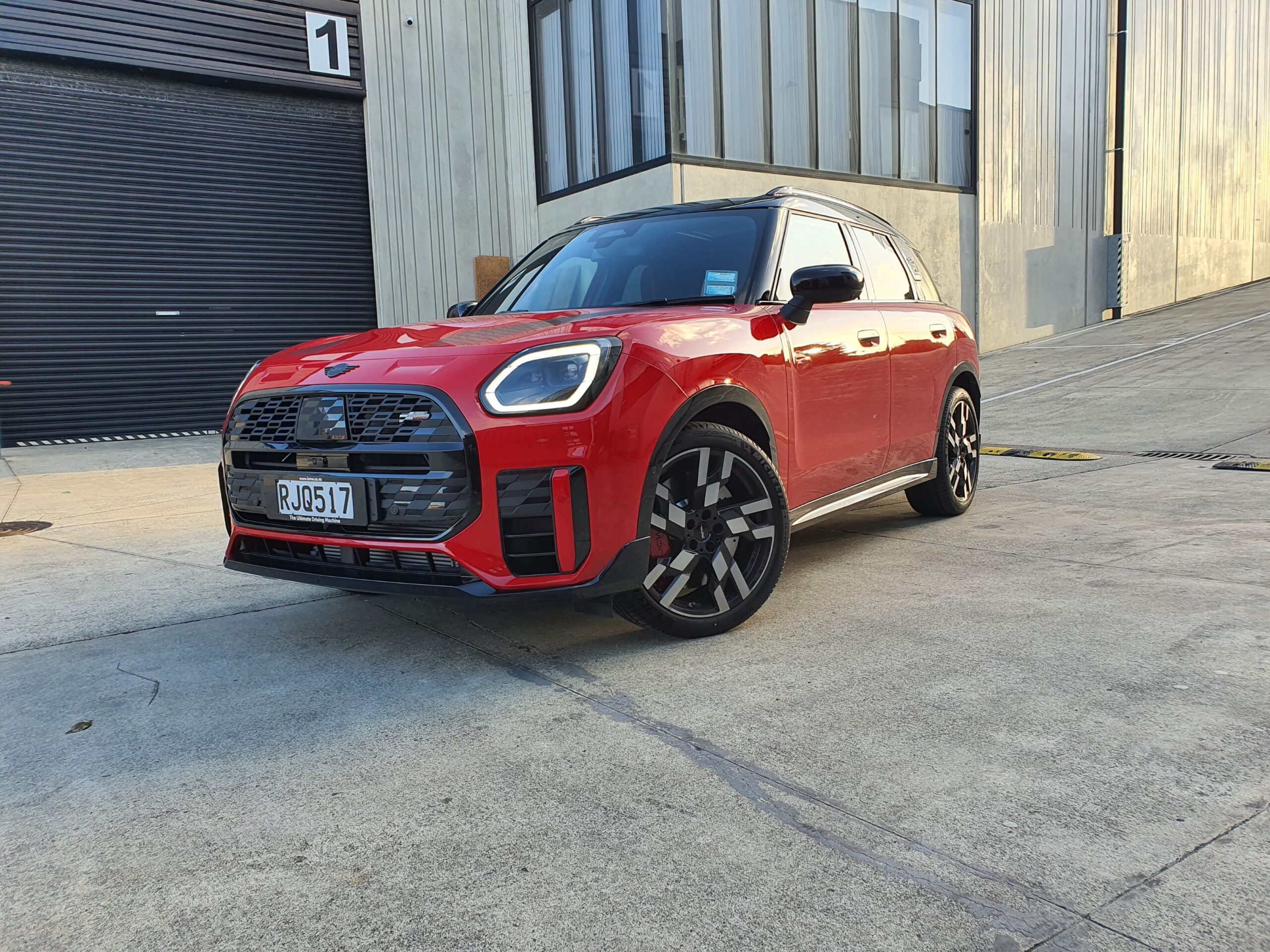Front three quarters view of a 2025 Mini Countryman John Cooper Works in Red with a Black roof.